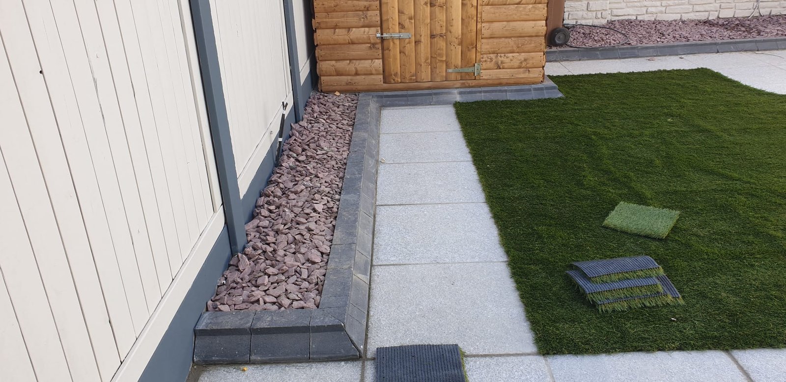 Outdoor garden with artificial grass and paving stones