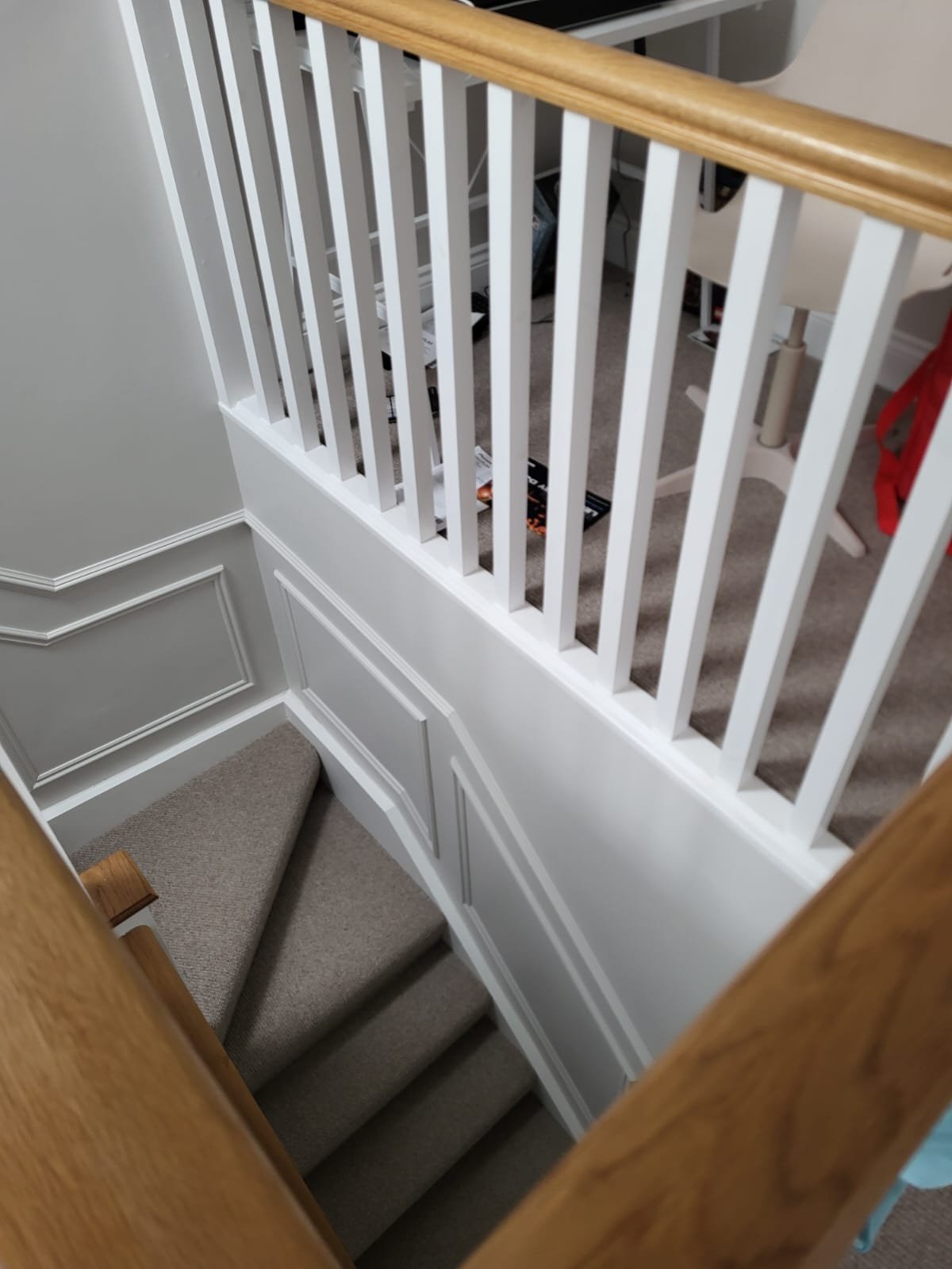 Staircase with white balustrade and wooden handrail detail