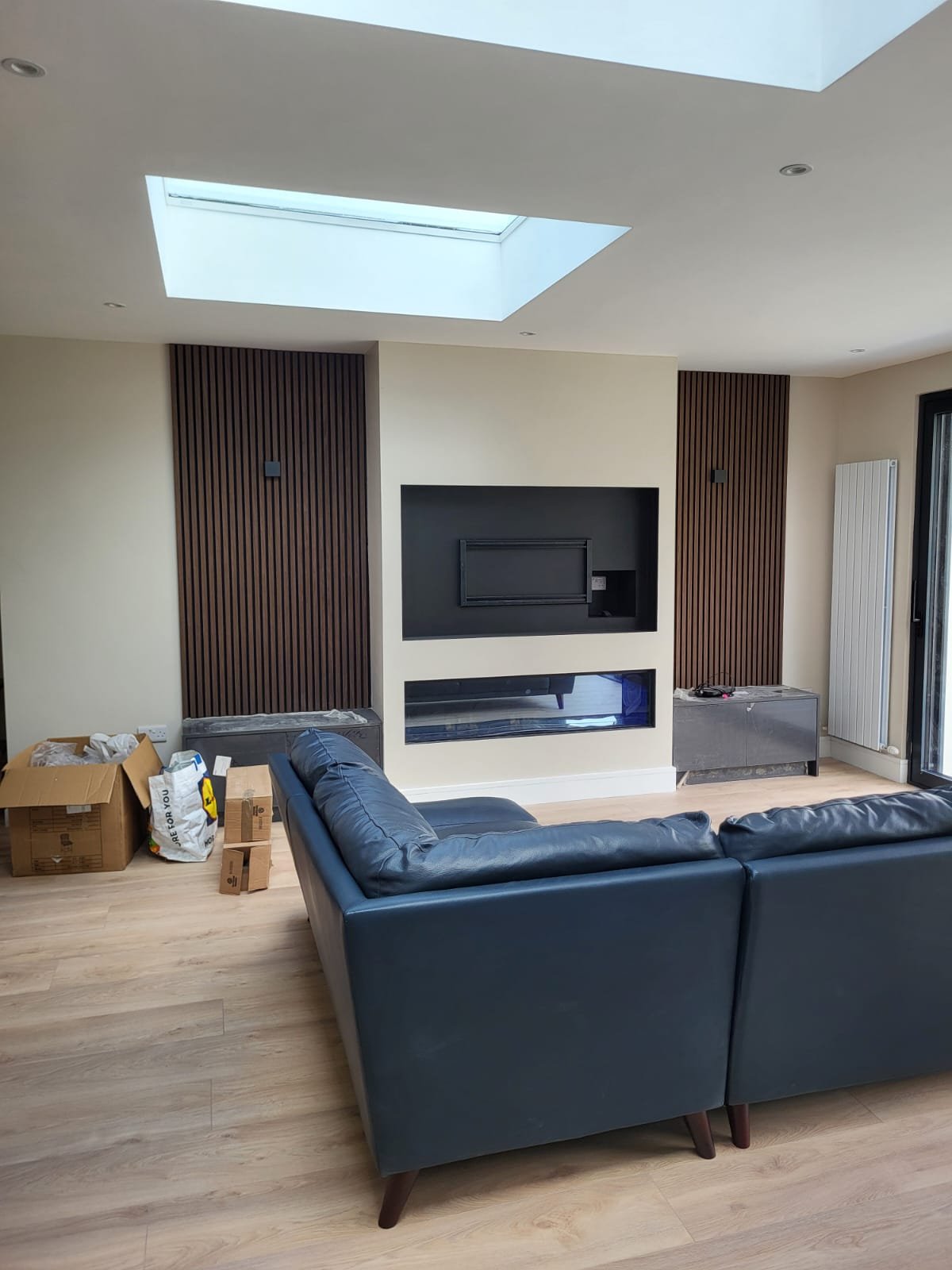 Living room with skylight & TV wall