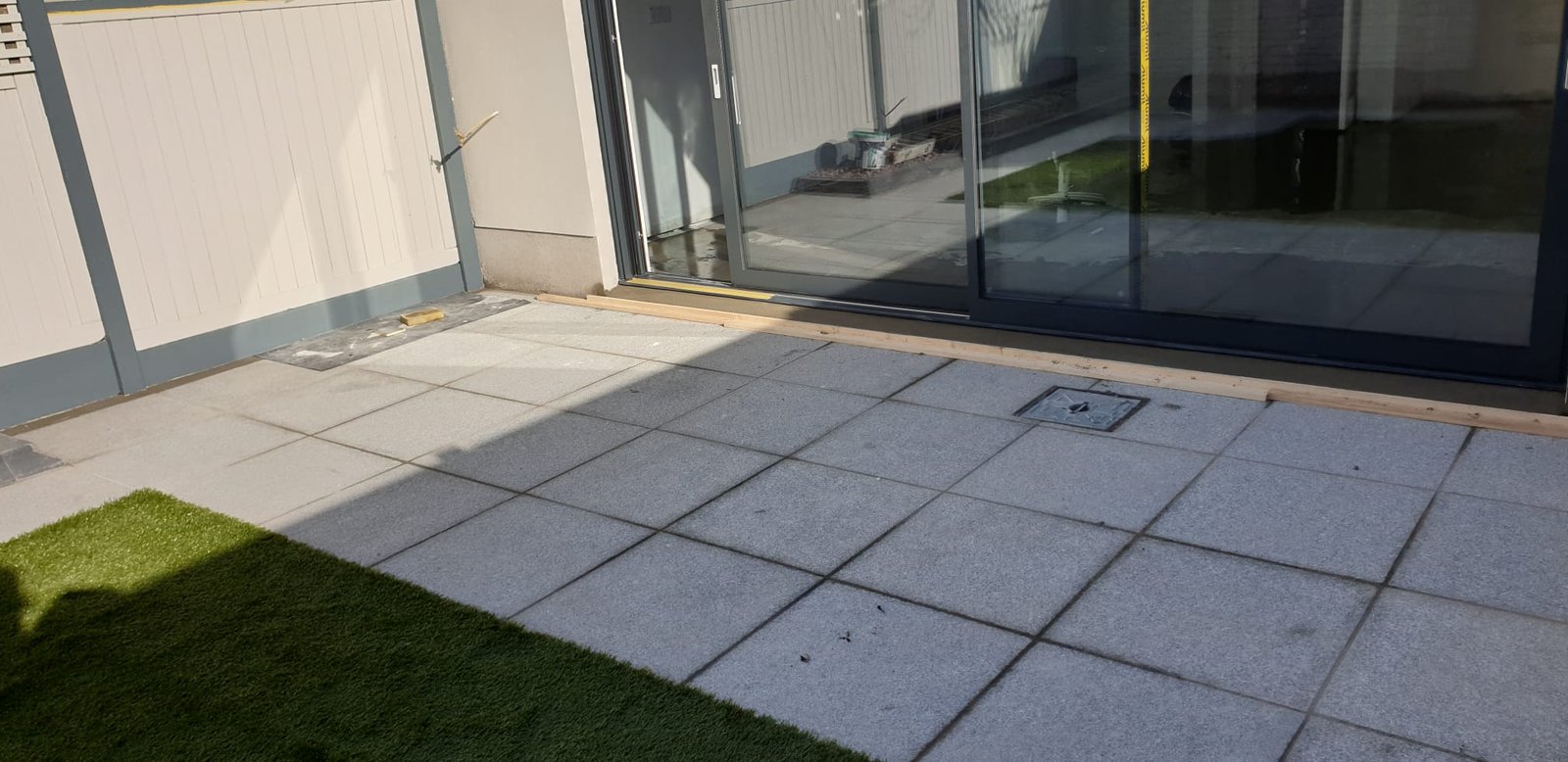 Modern patio with black bi-fold doors and paving