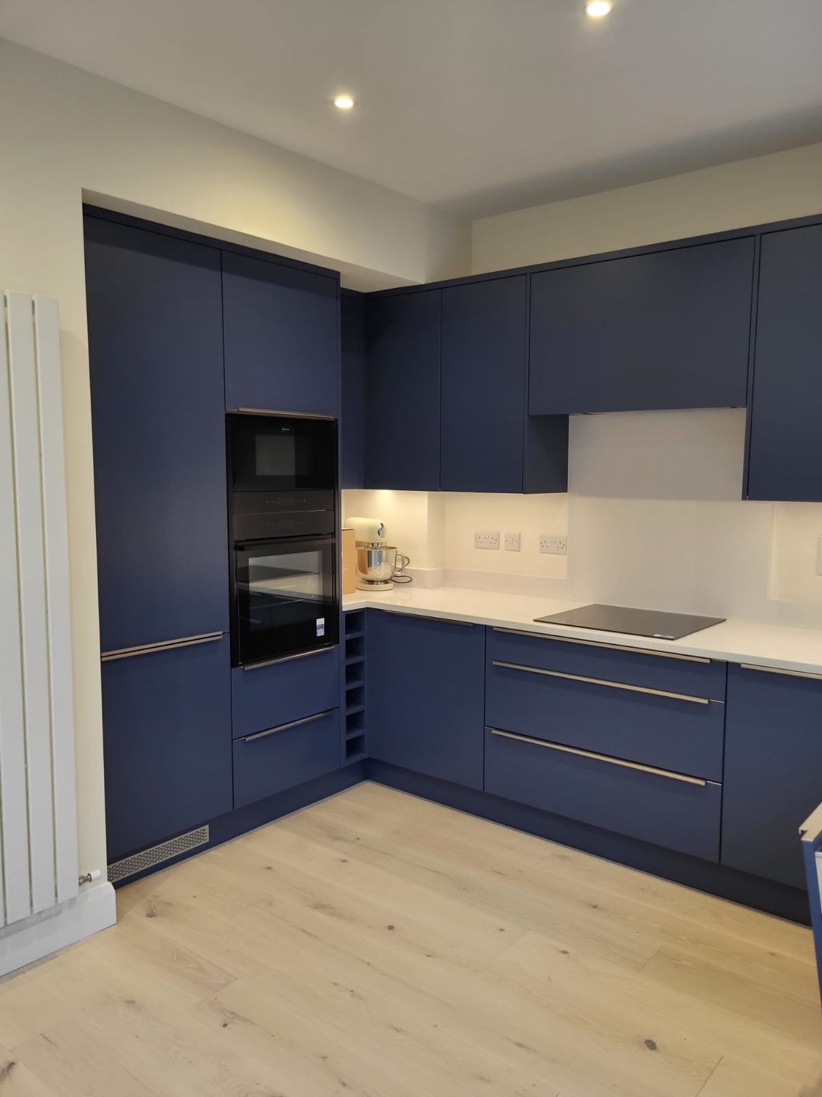 Modern kitchen with dark navy cabinetry and white countertops