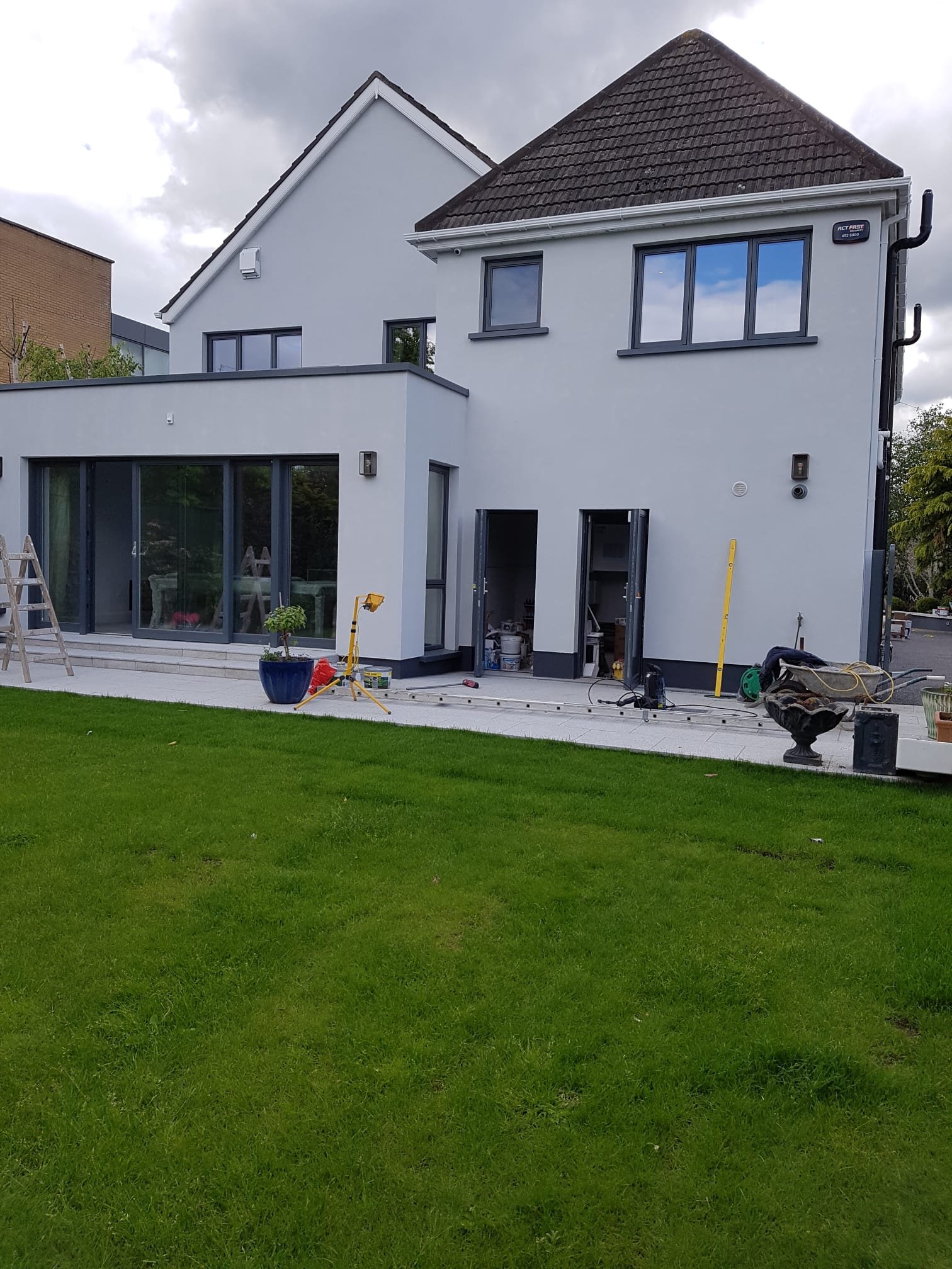 House exterior during construction with scaffolding and white render