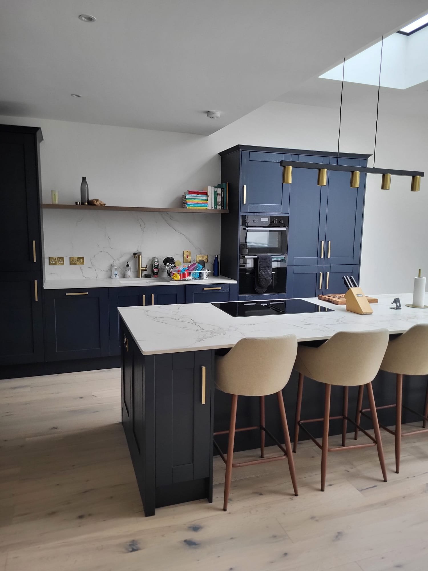 Modern house extension exterior with black-framed glass doors and white patio