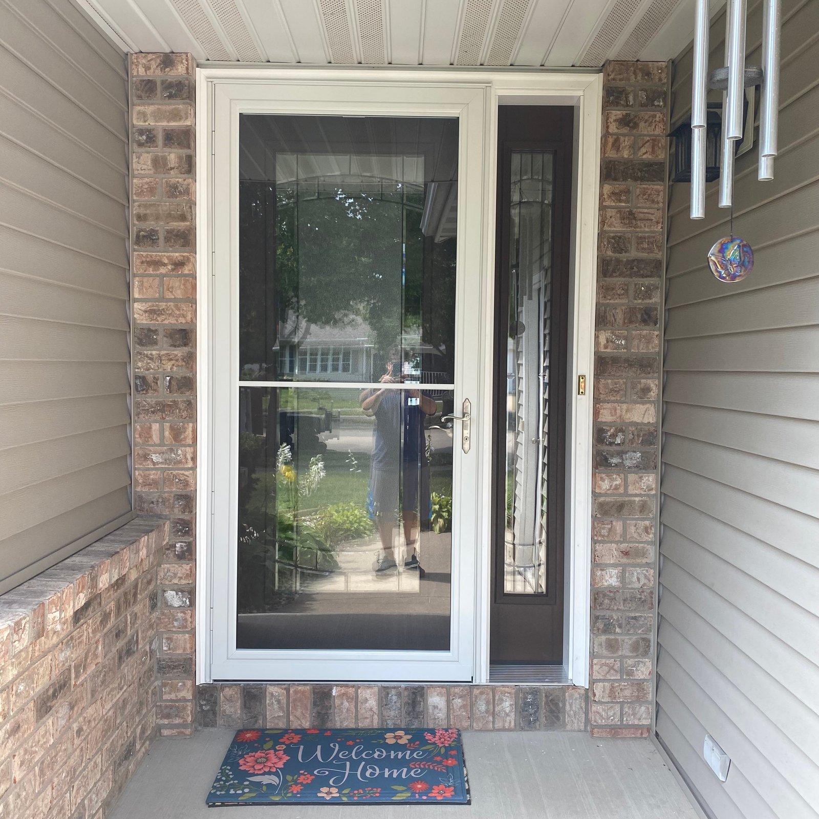 Newly installed white double-hung window with interior trim looking out to a suburban street and trees in Appleton, WI
