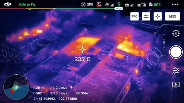 Thermal imaging of urban buildings showing temperature variations with warm zones in red and orange, and cold zones in blue and violet