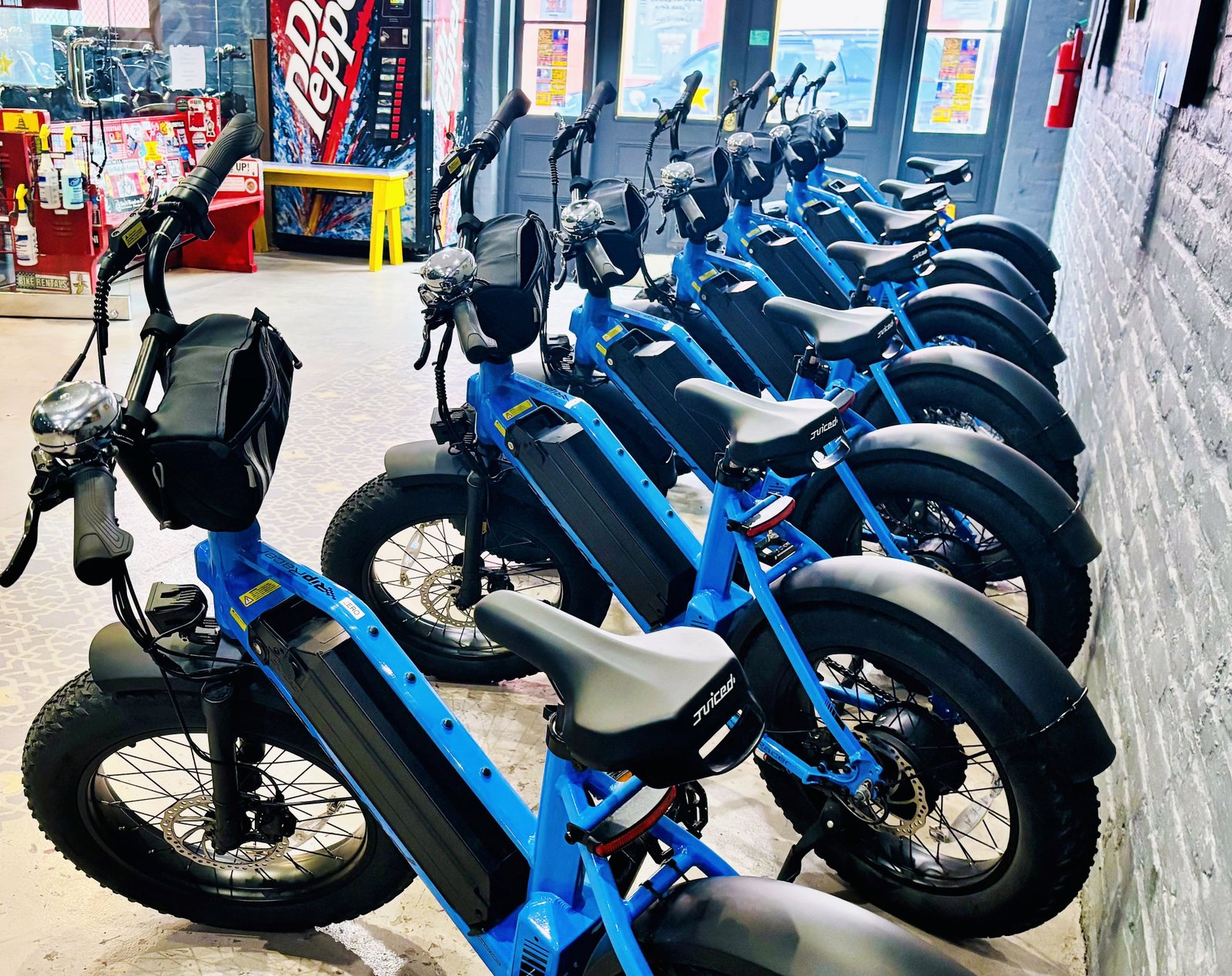 A row of blue electric bikes inside the French Quarter Go! rental shop