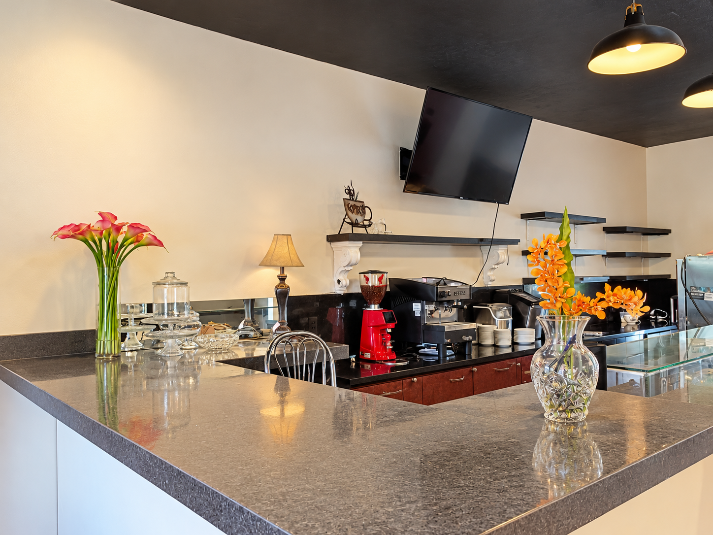 Coffee bar with calla lilies, orange orchids and a red grinder