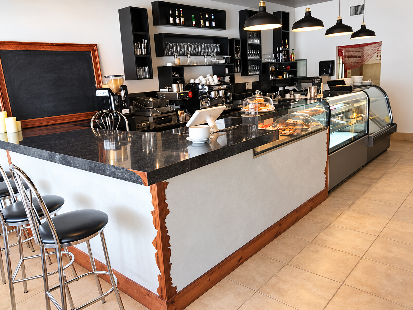 Pastry display case and granite counter with chrome stools at TARNA