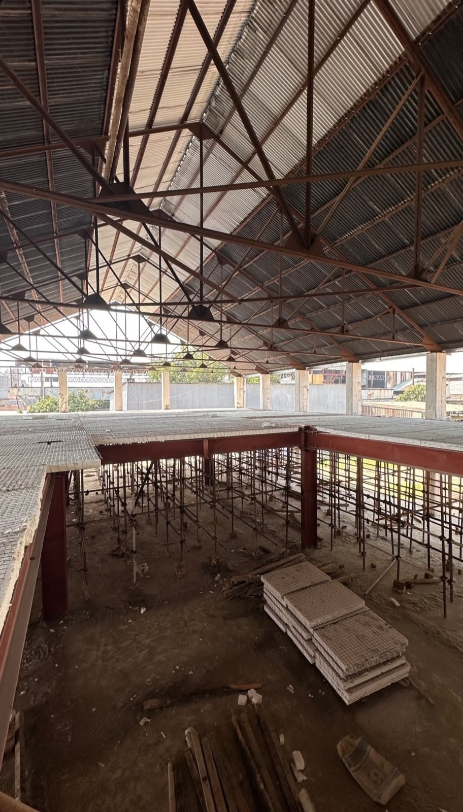 Steel mezzanine under a corrugated roof with decking and scaffolding