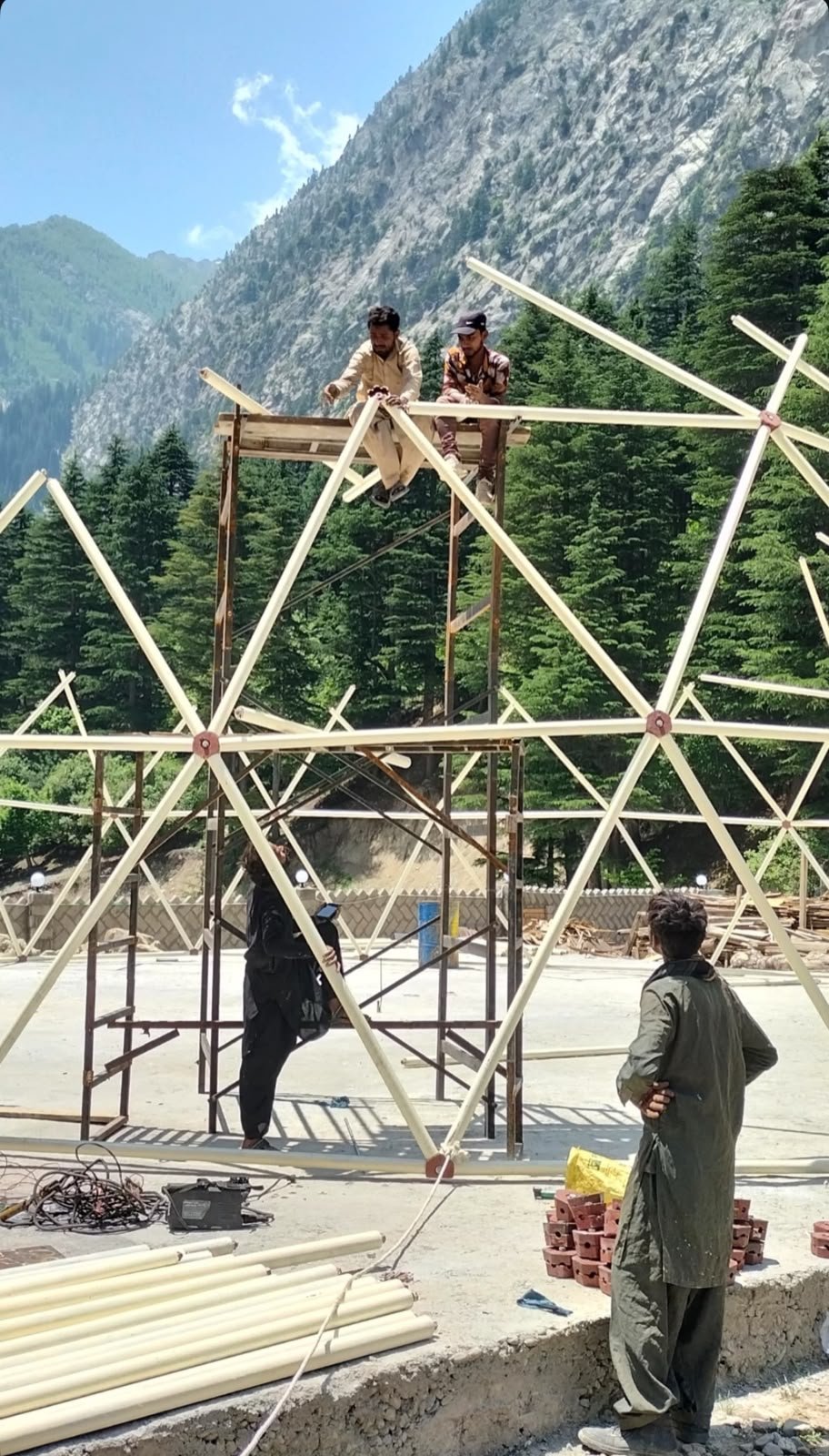 Crew erecting an Event Dome frame against a mountain backdrop