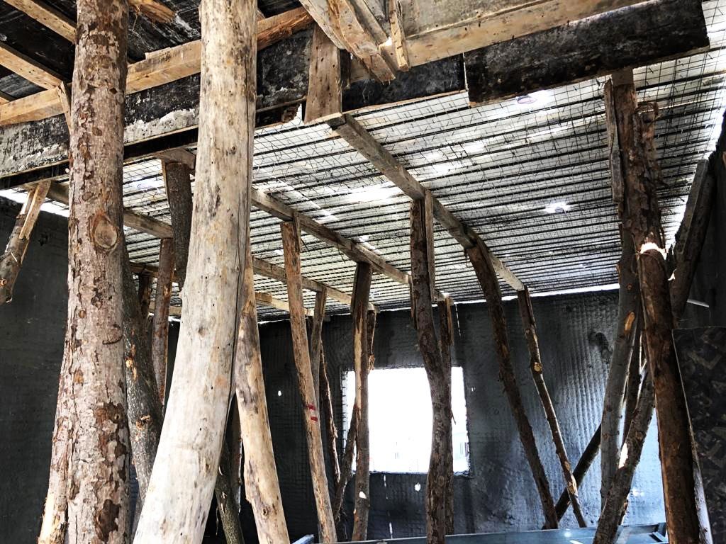 Interior timber props holding a wire-mesh ceiling during house construction