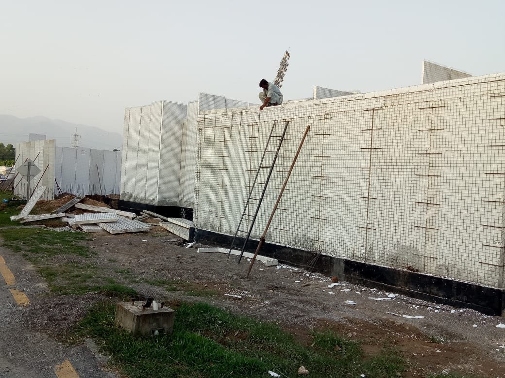 Worker installing reinforced mesh panels at the construction site