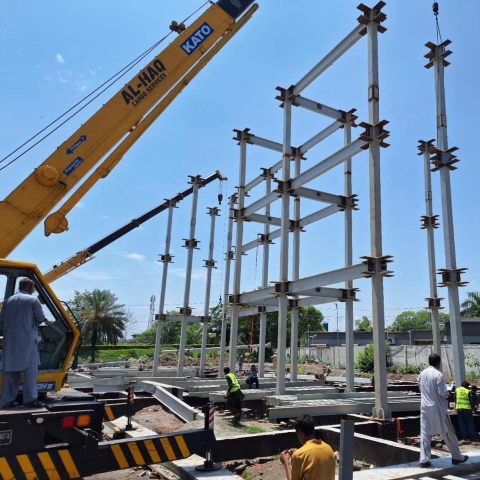 Steel frame erection with crane and workers on site