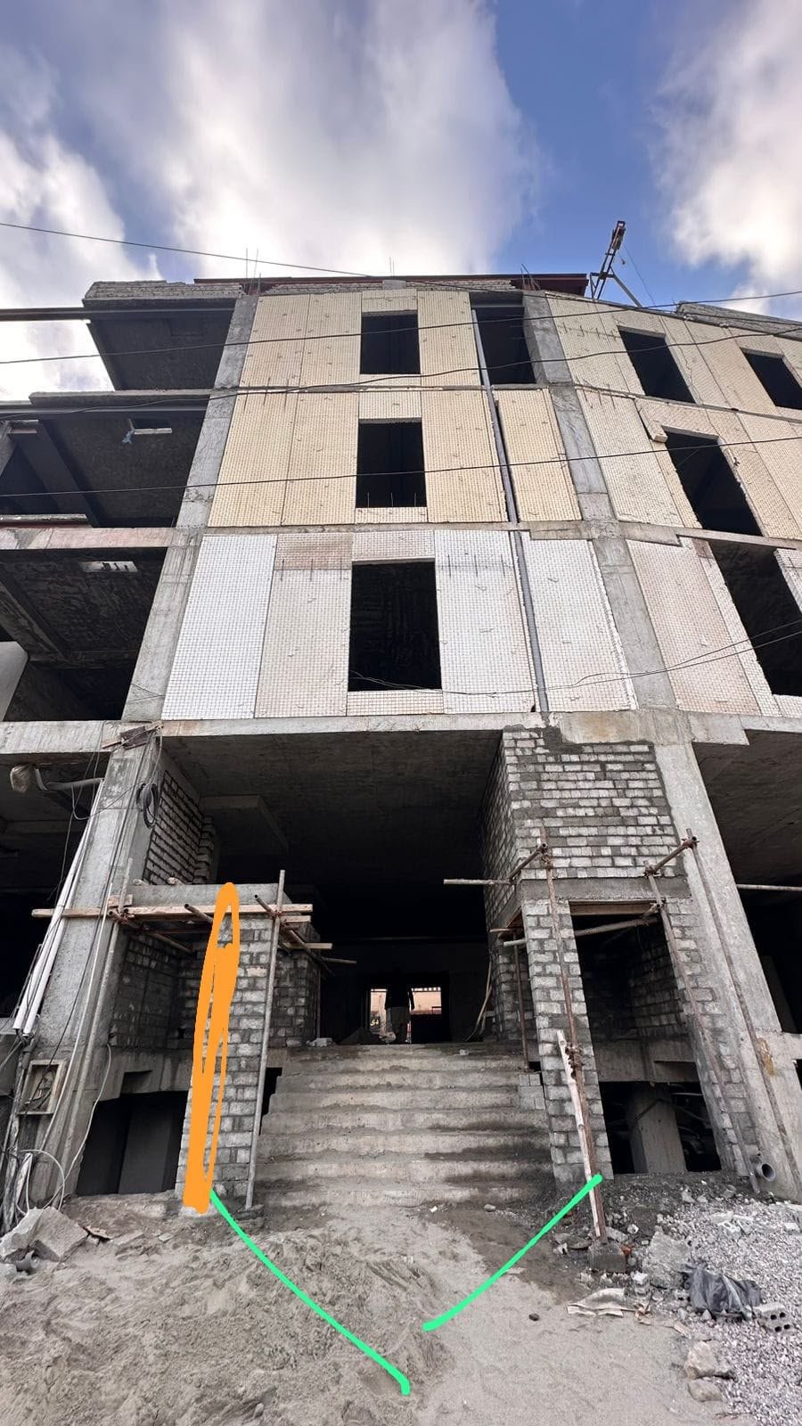 Ali Centre building shell with tiled facade panels and entrance stairs under construction