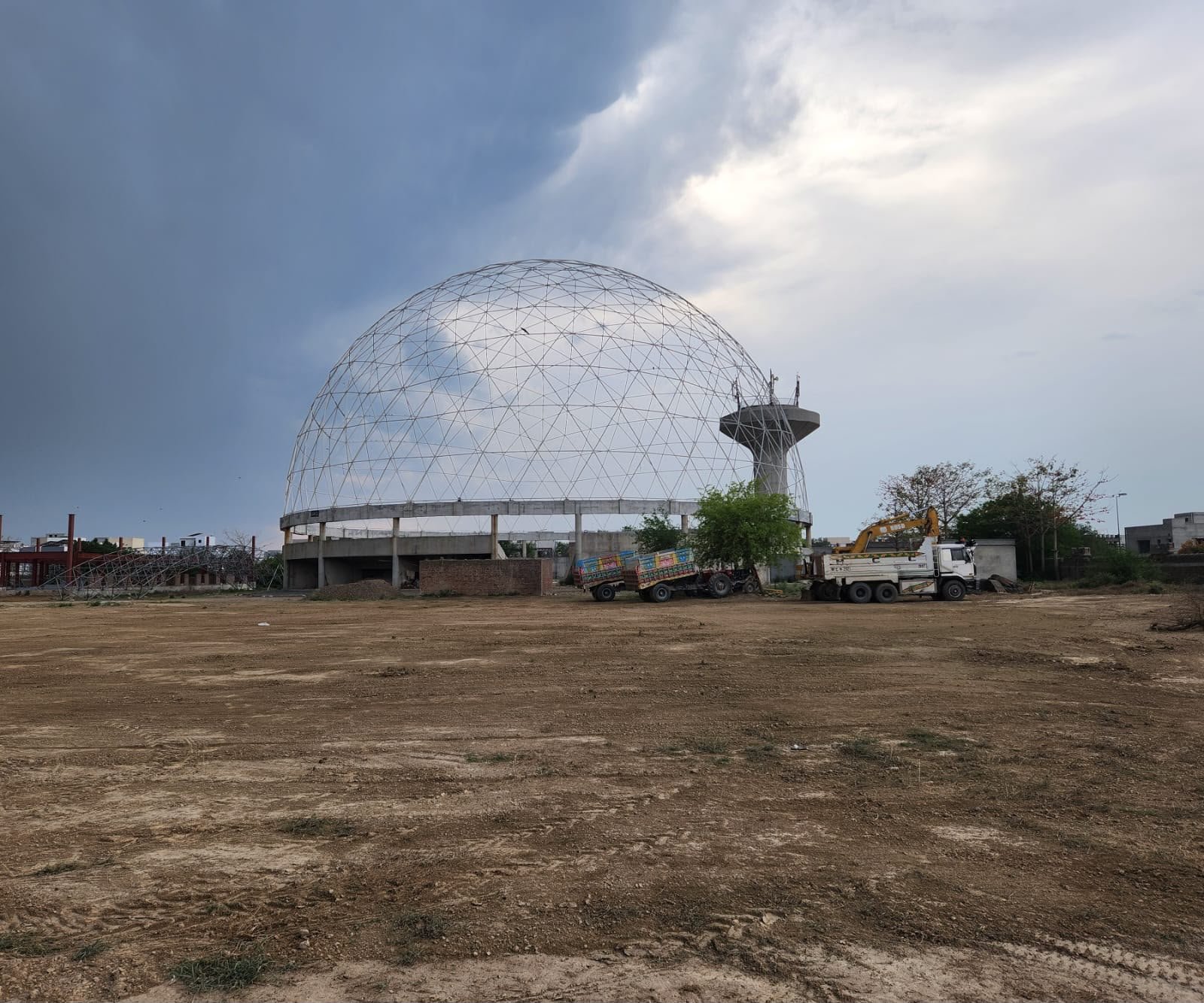 Large steel Event Dome raised on a concrete ring beam at a construction site