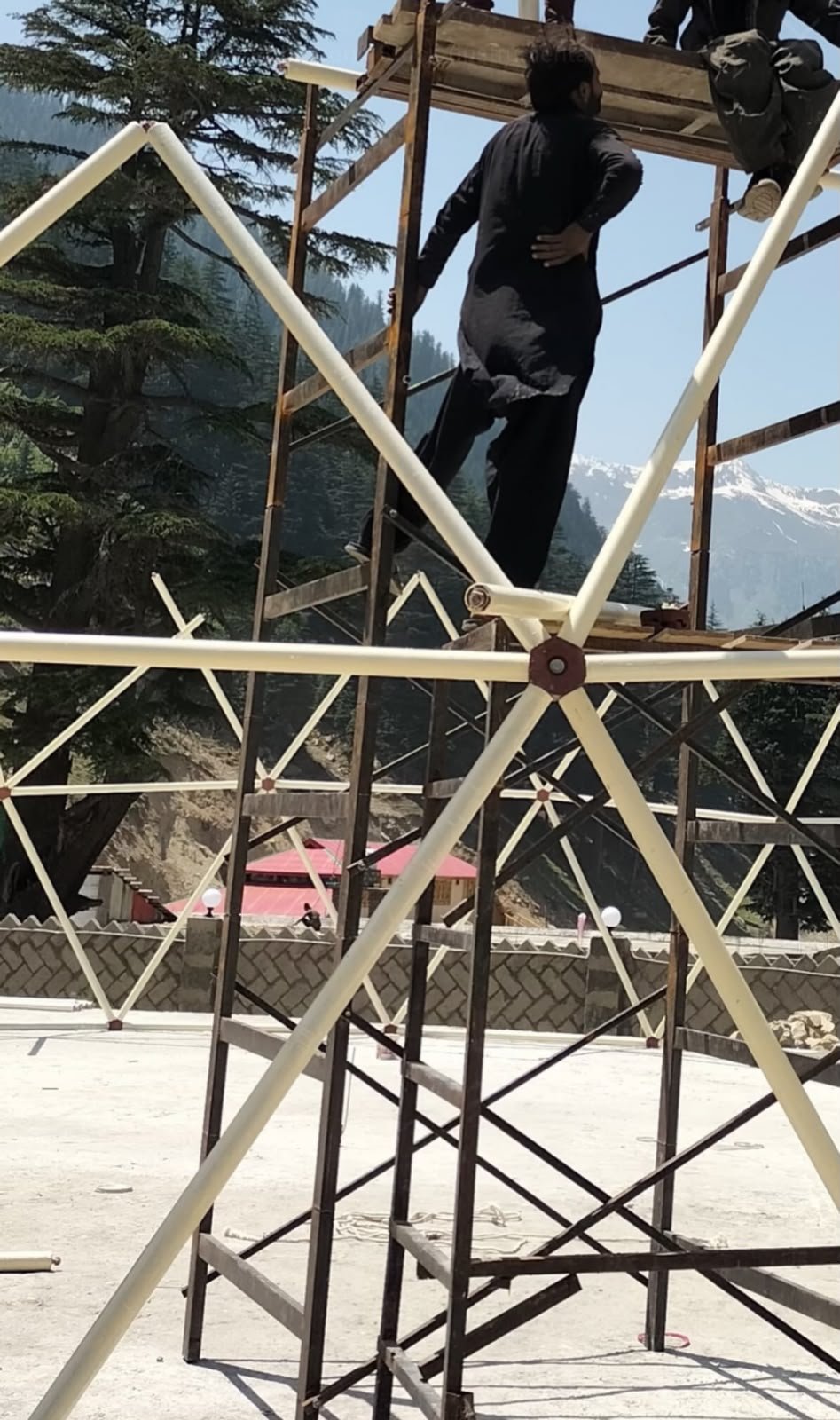 Event Dome frame being assembled on scaffolding in the mountains