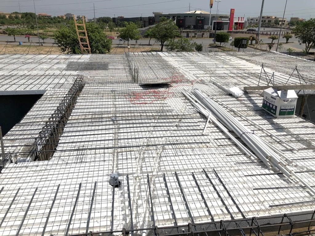 Reinforced roof deck with conduit and PVC pipes before concrete pour