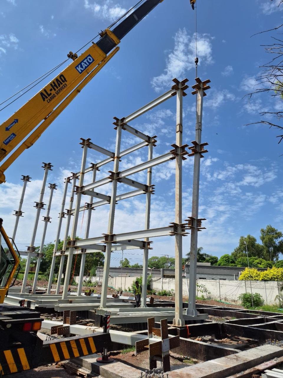 Crane lifting steel members during building frame erection