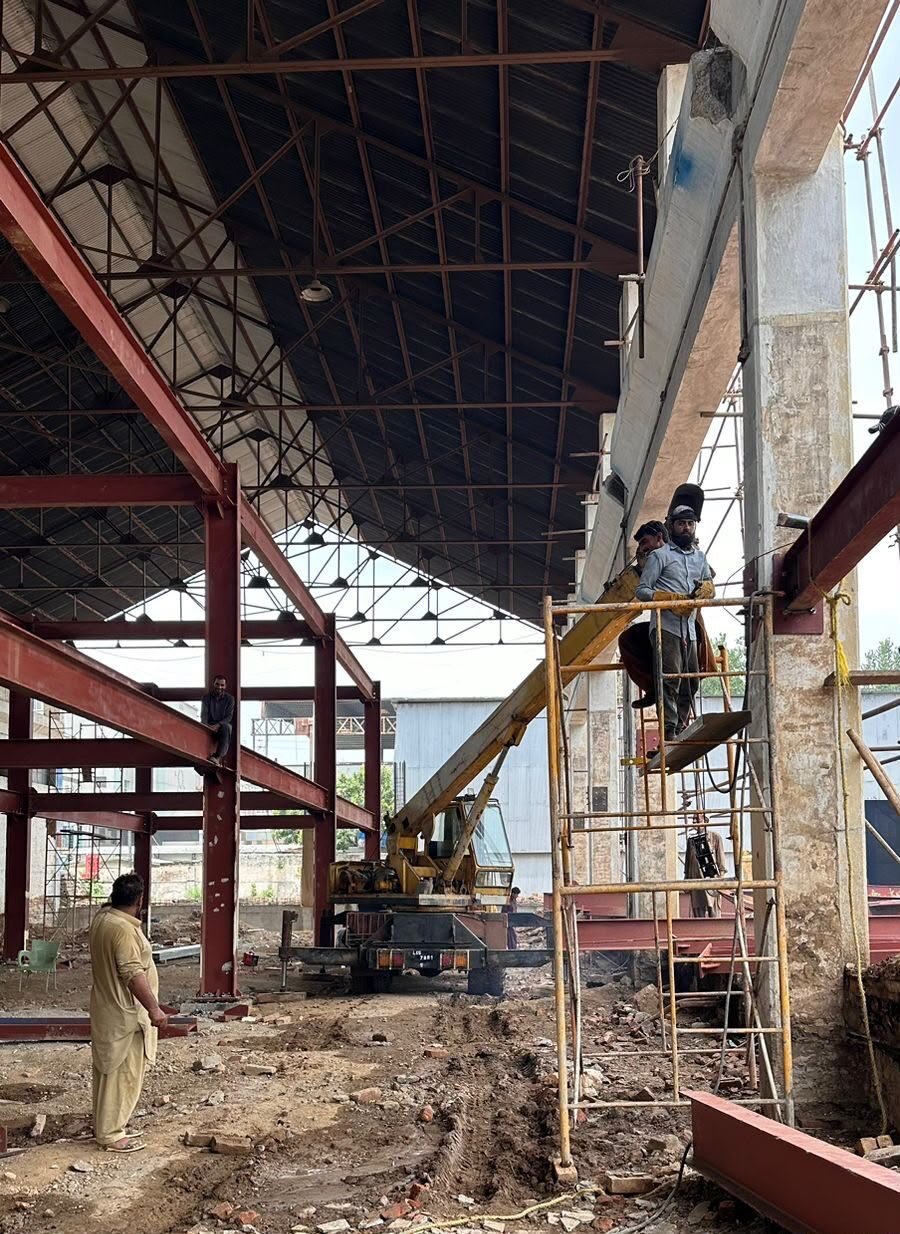 Workers assembling a steel mezzanine and roof structure