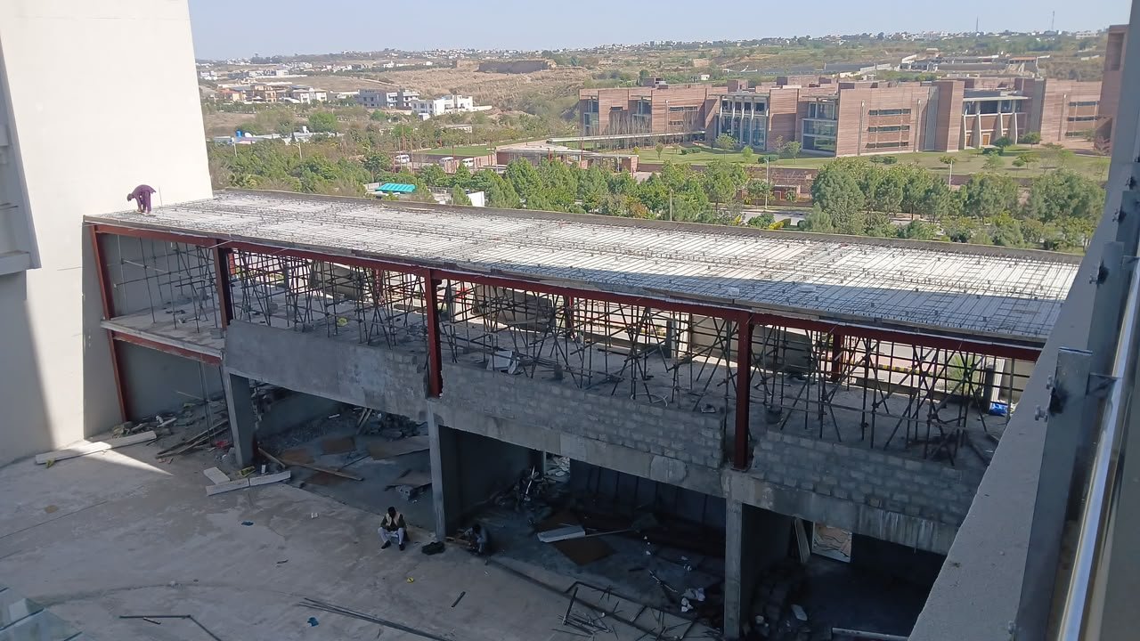 Long steel deck with reinforcement mesh and workers on the upper level