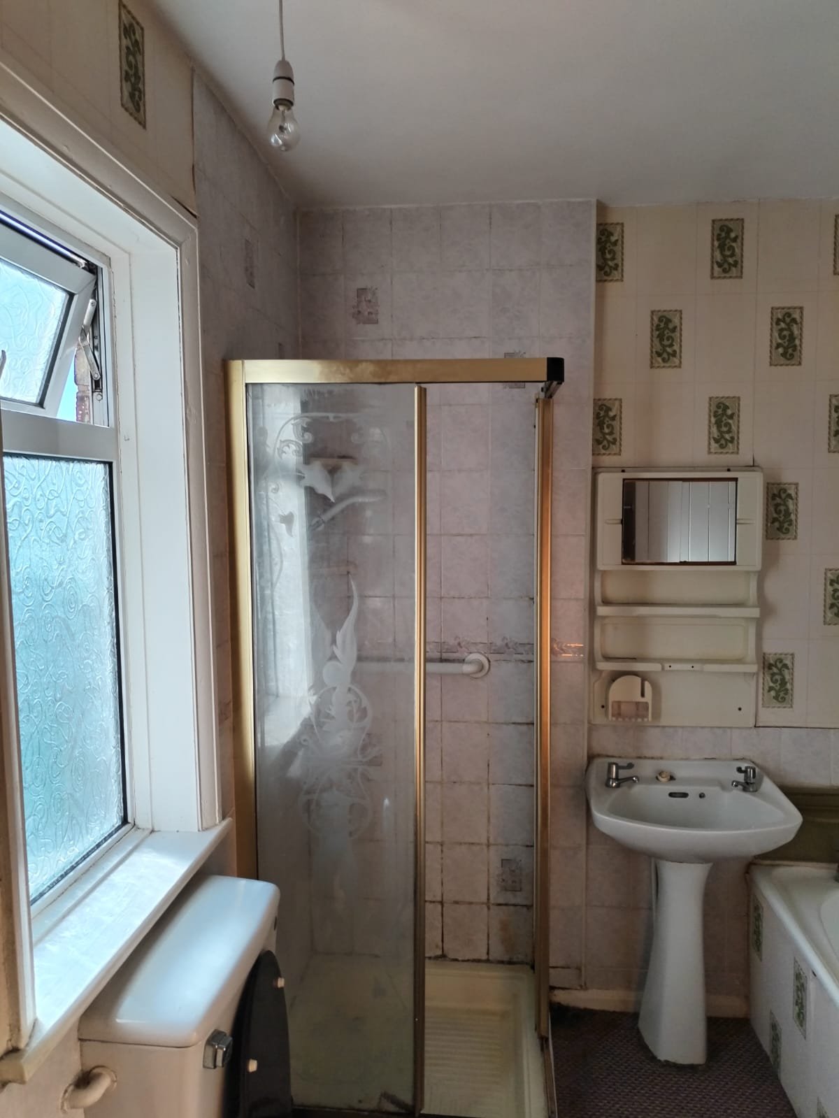 Completed modern bathroom with white subway tiles, black accents, gold fixtures, and contemporary shower