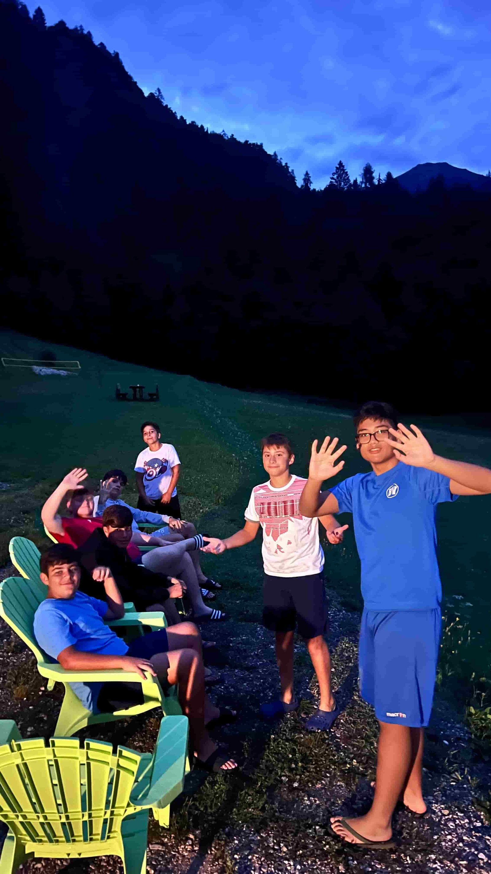 Il gruppo festoso sulle sedie verdi davanti alla montagna al tramonto