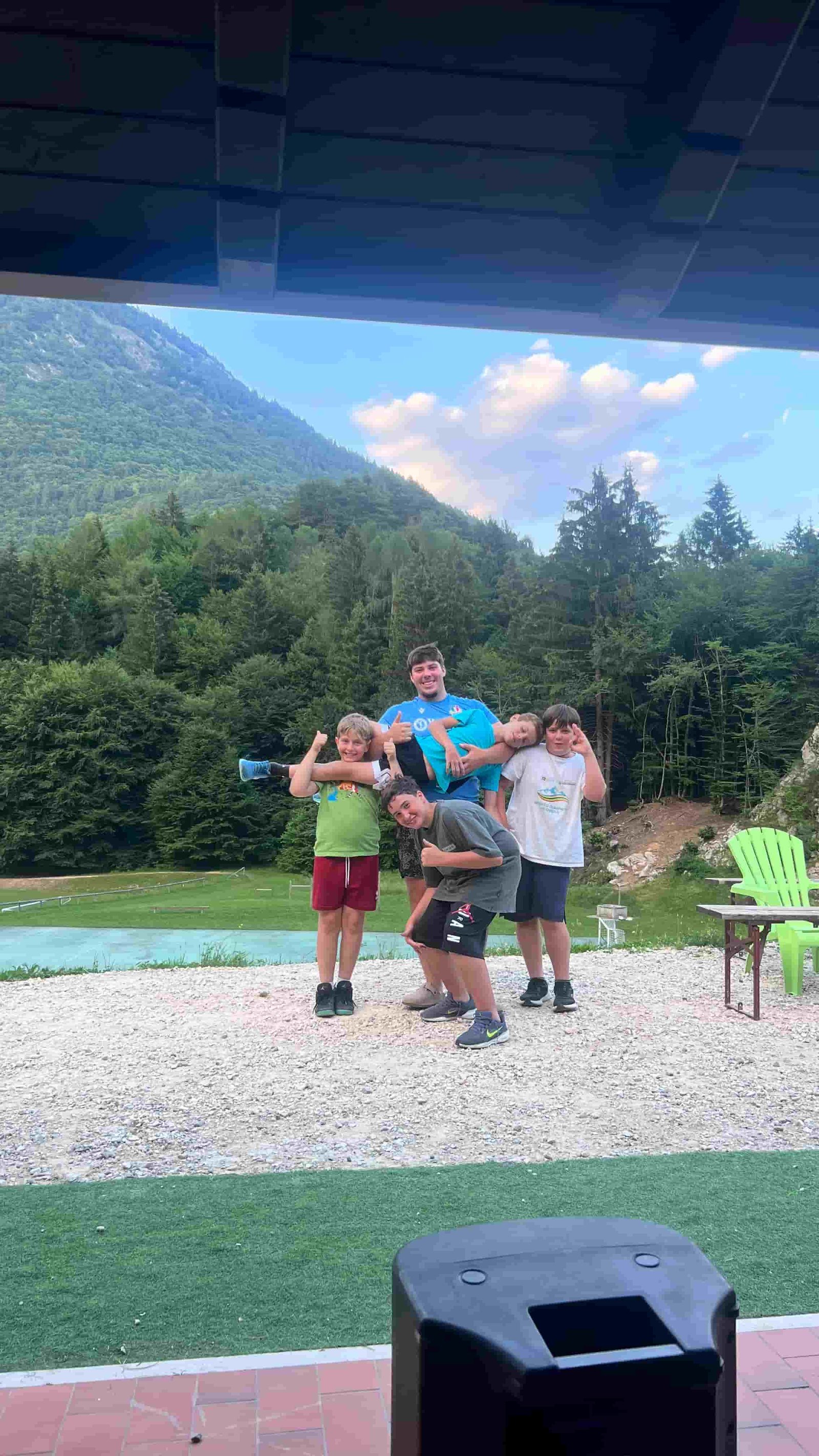 Gruppo di ragazzi in posa davanti al bosco e alla montagna