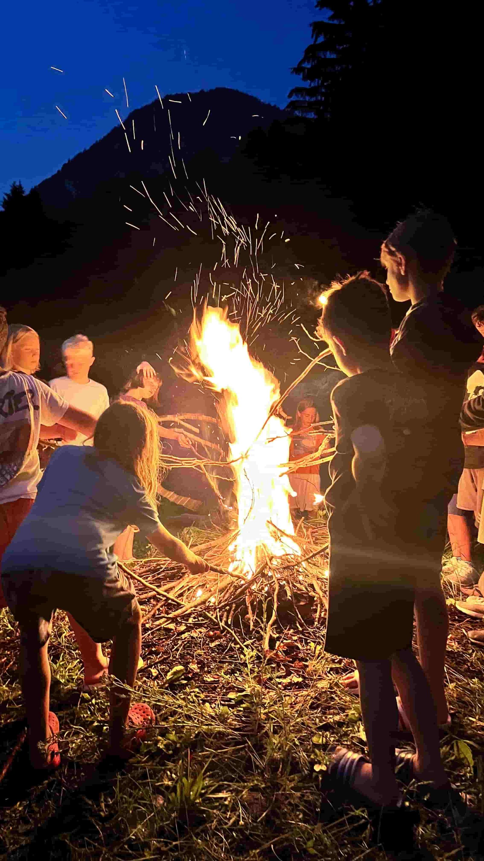 I ragazzi attorno al fuoco durante la serata in montagna