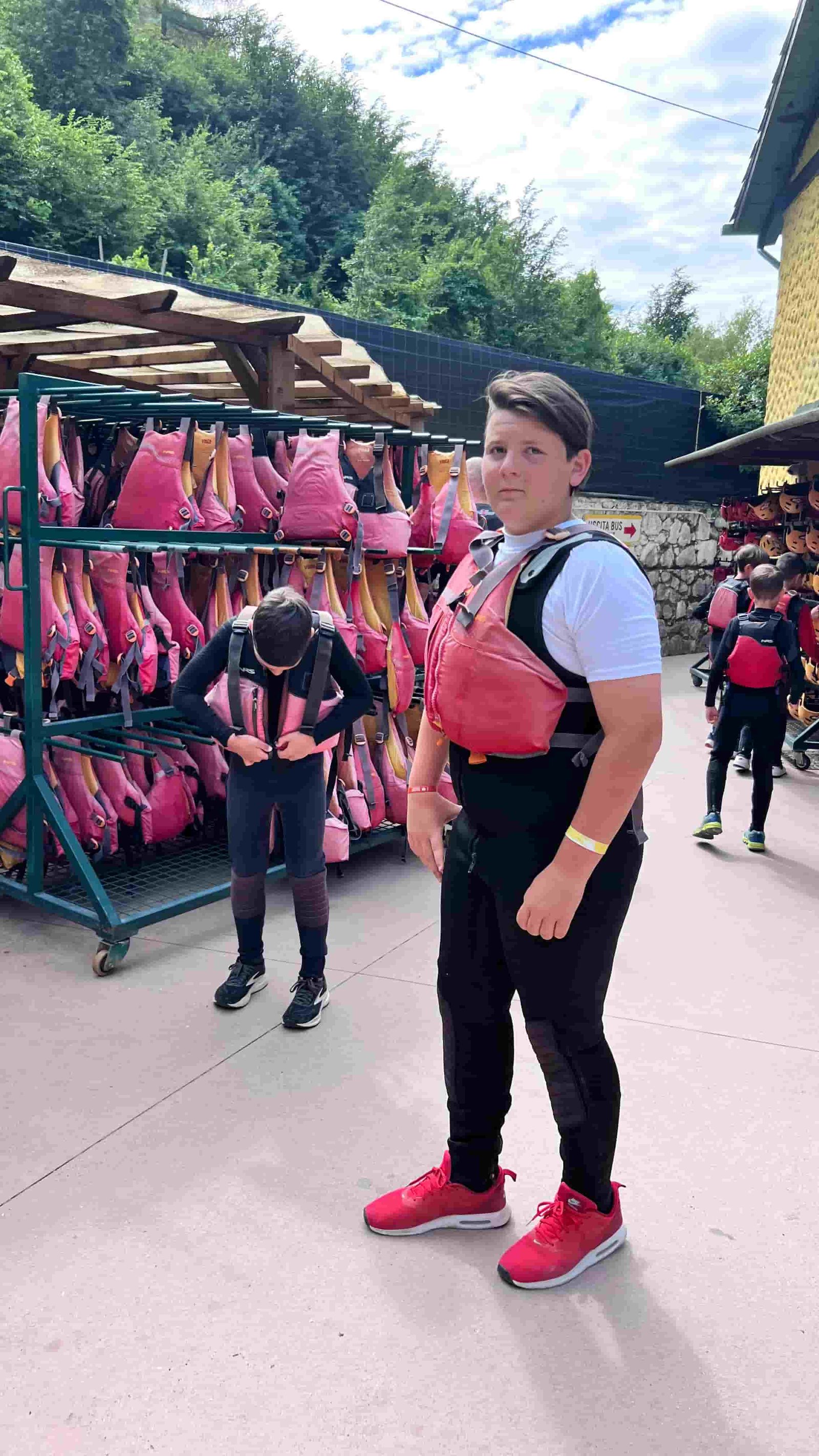Un ragazzo pronto per la discesa in rafting davanti al deposito dei salvagenti