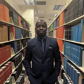 Formal portrait of Dr. Jean Narcisse Djaha in a dark aubergine suit