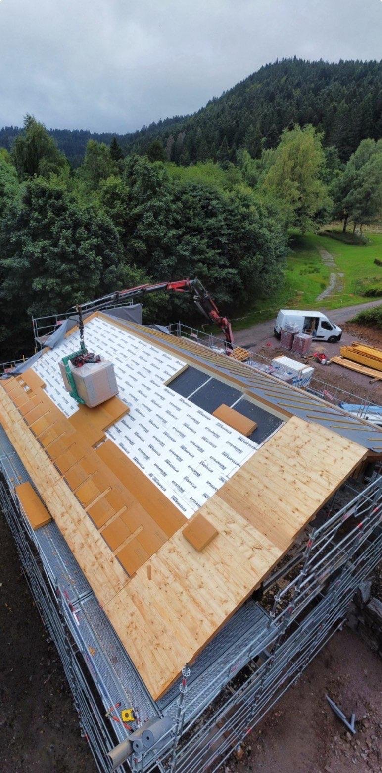 Pose d’isolant et de panneaux de toiture sur une maison, vue aérienne du chantier