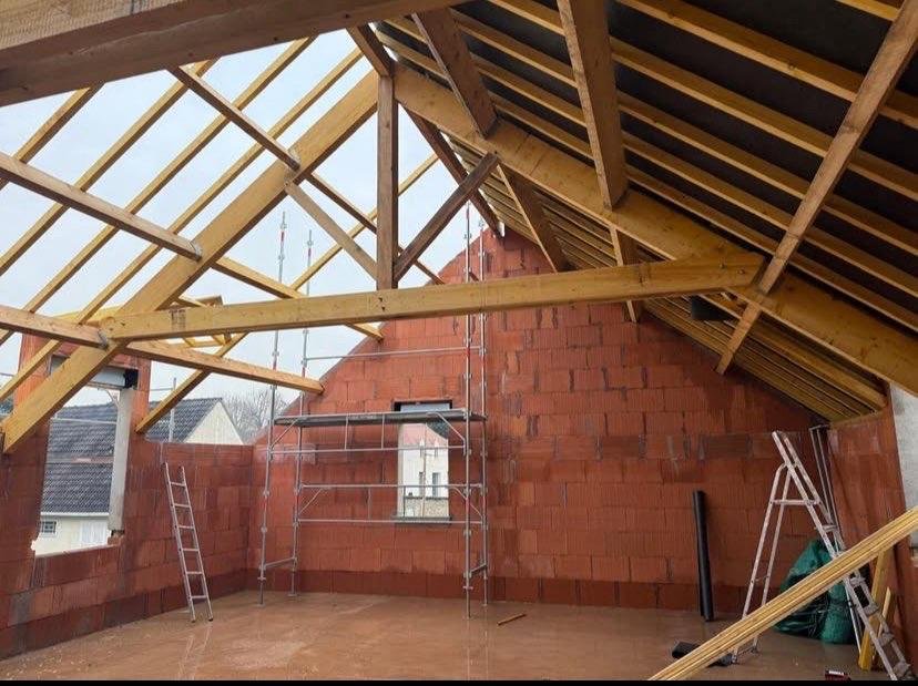 Charpente bois en cours de montage à l’intérieur d’une maison en construction