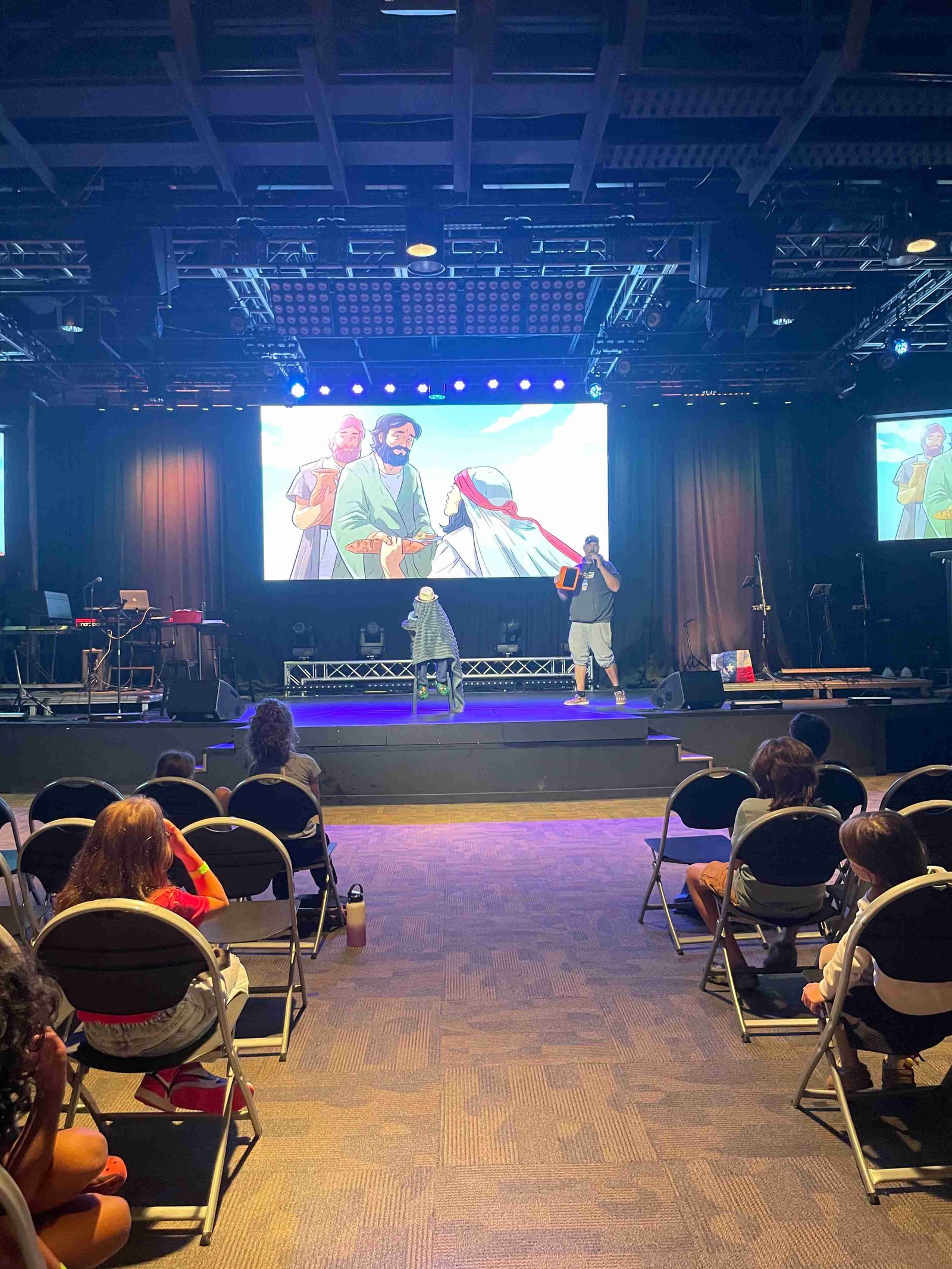 Speaker on stage teaching with biblical illustration