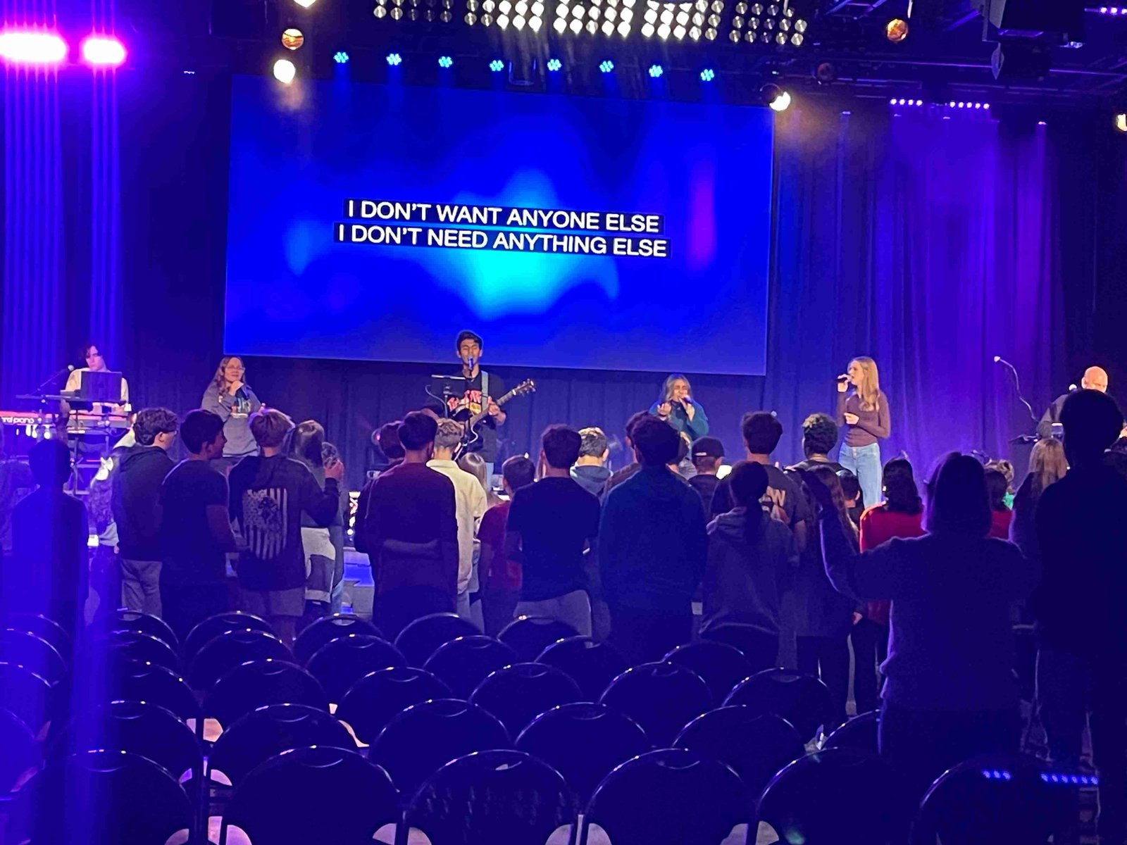 Worship band leading praise with lyrics on screen
