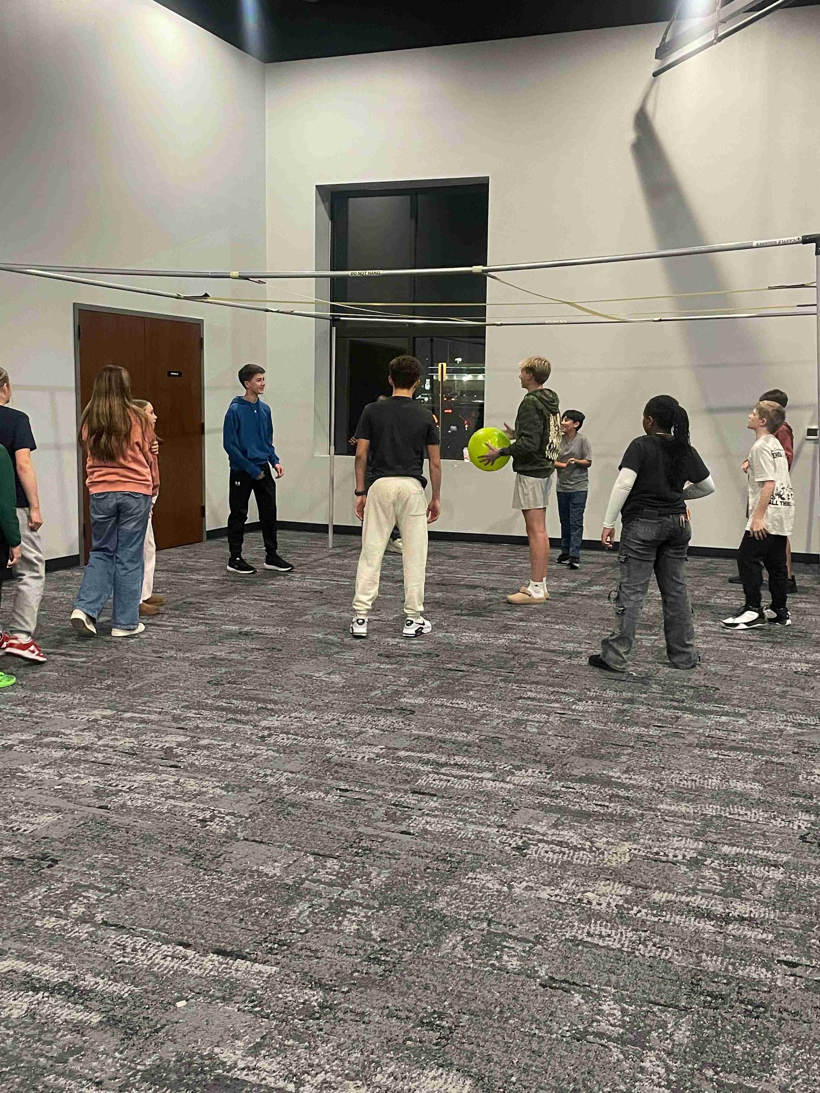Group of youth playing 9-square game indoors