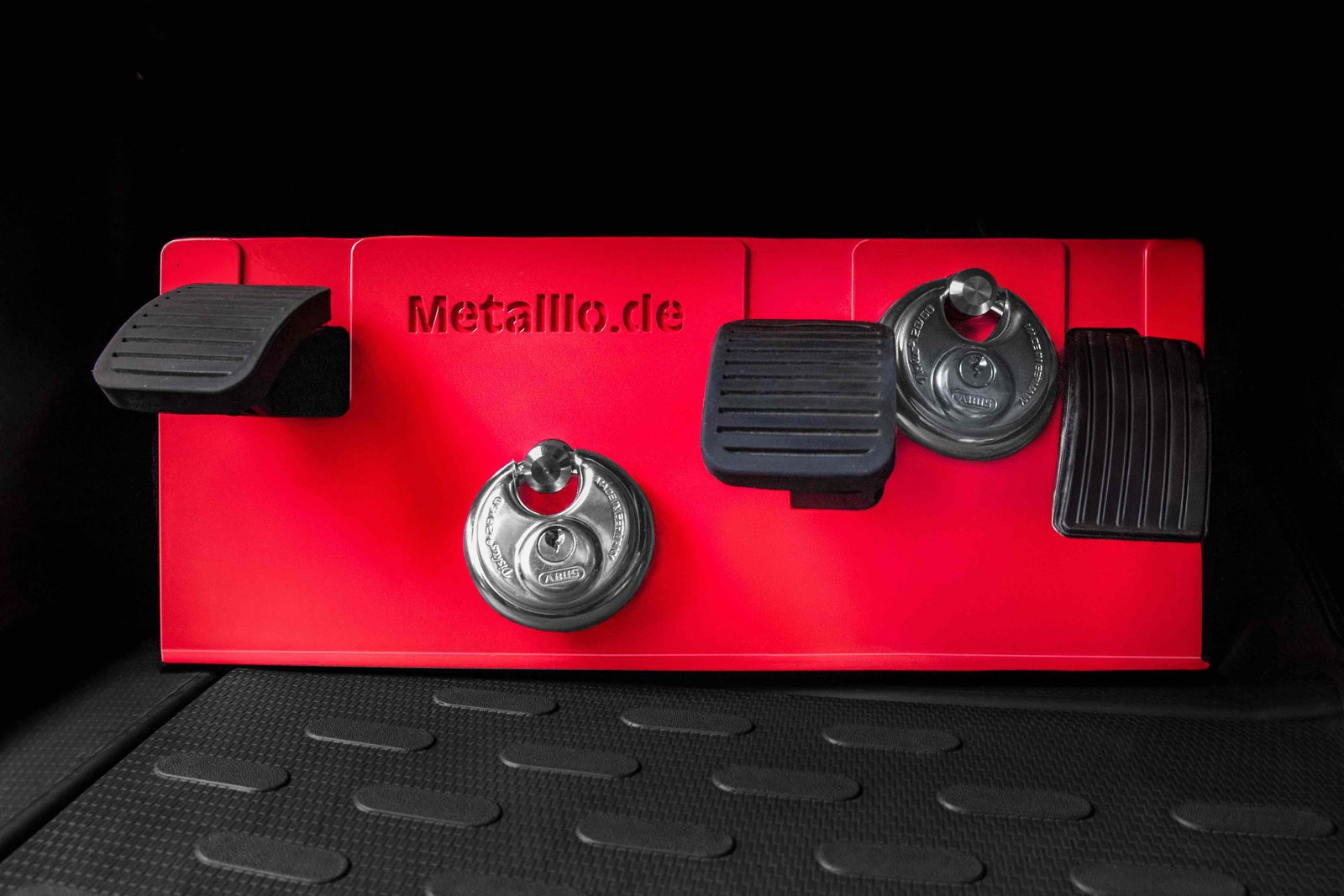 Rote Pedalsperre von Metalllo.de mit ABUS Schlössern im Fußraum eines Fahrzeugs