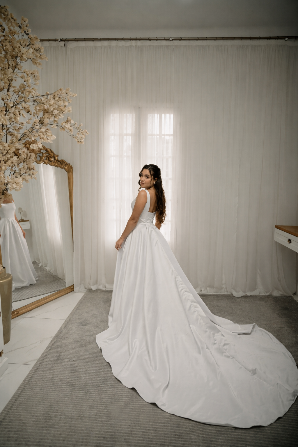 Noiva em vestido evasê branco com cauda longa em quarto elegante
