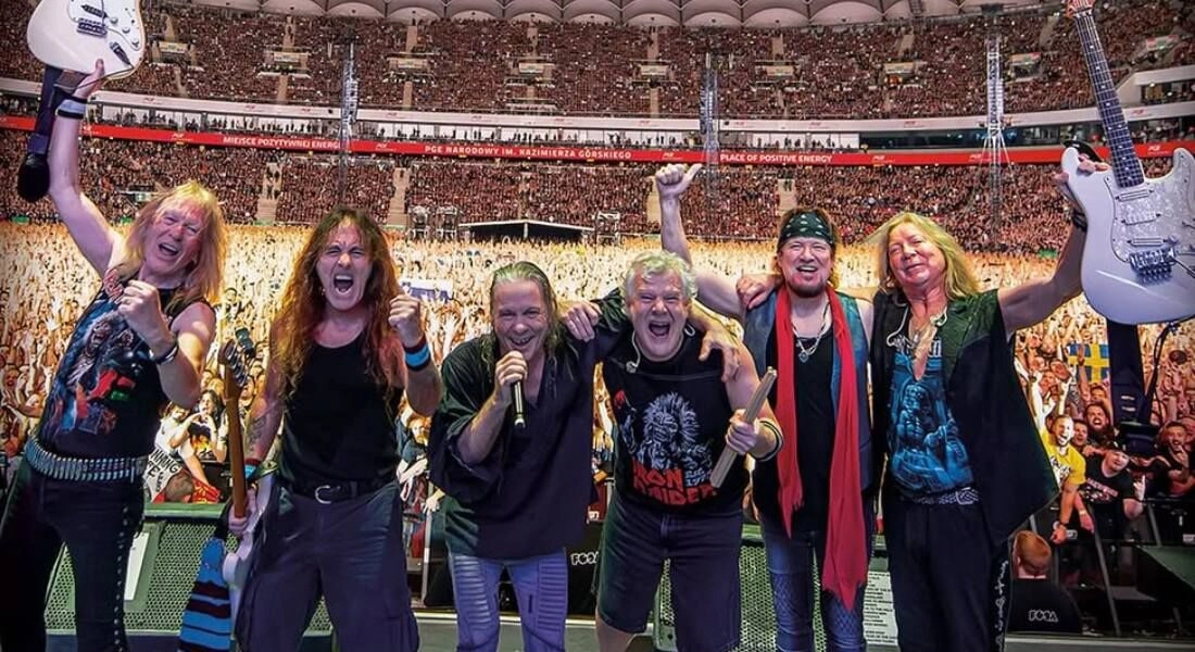 Integrantes do Iron Maiden diante de uma arena lotada