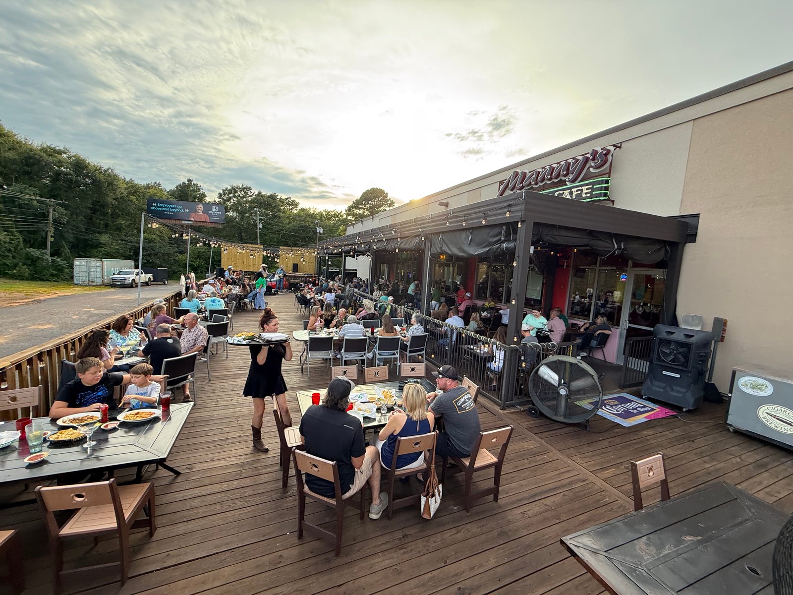 Guests on the patio during live music at Manny's