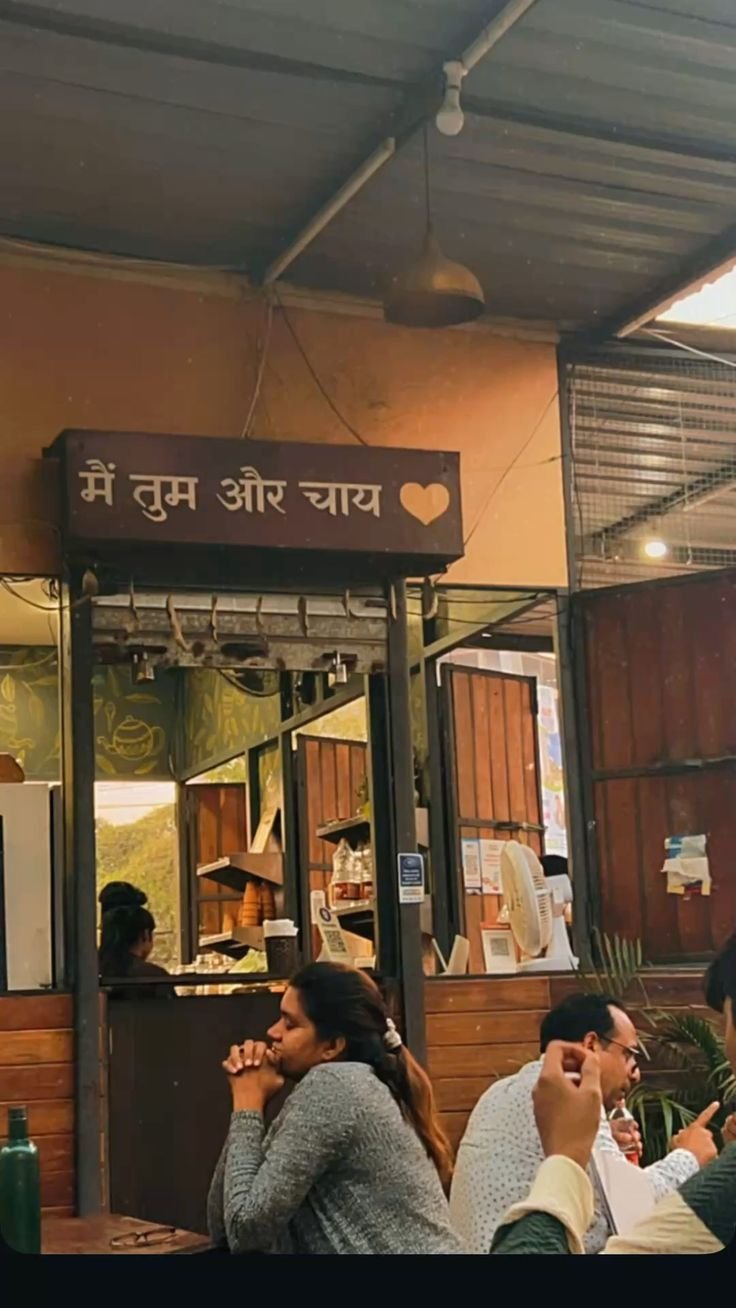 Indian café counter with Hindi signage मैं तुम और चाय, wooden booth, and guests at tables