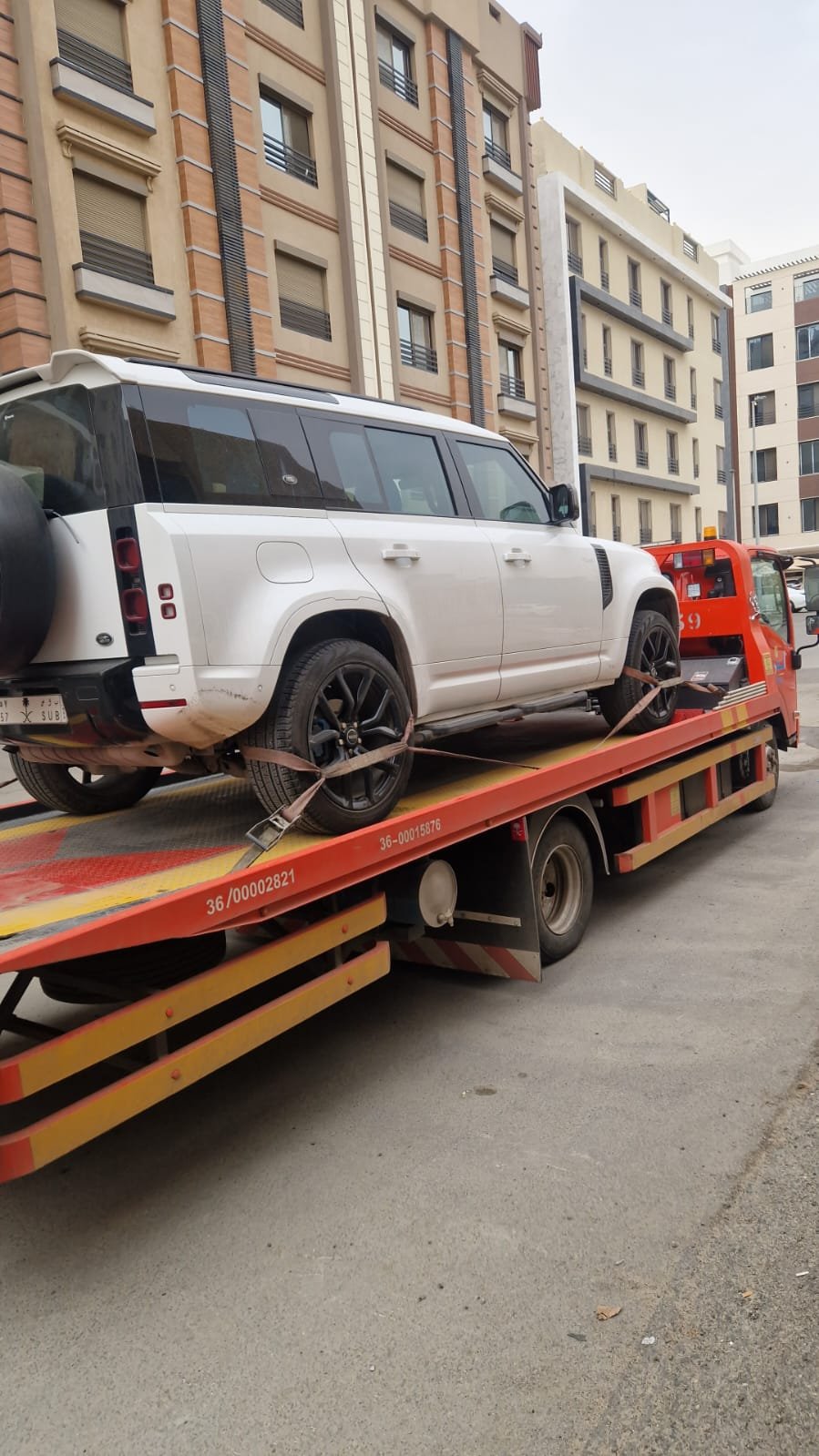 لاند روفر أبيض مثبت على سطحة نقل