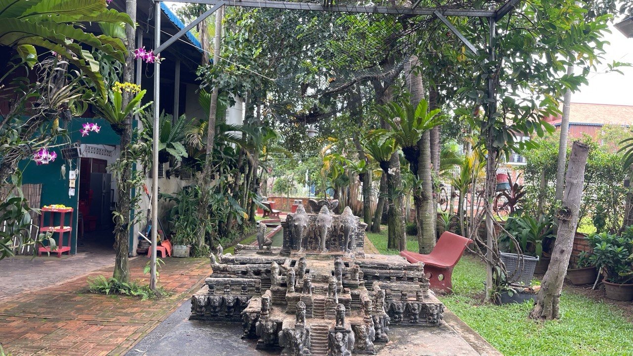Temple-themed mini golf course with pergola and tropical garden