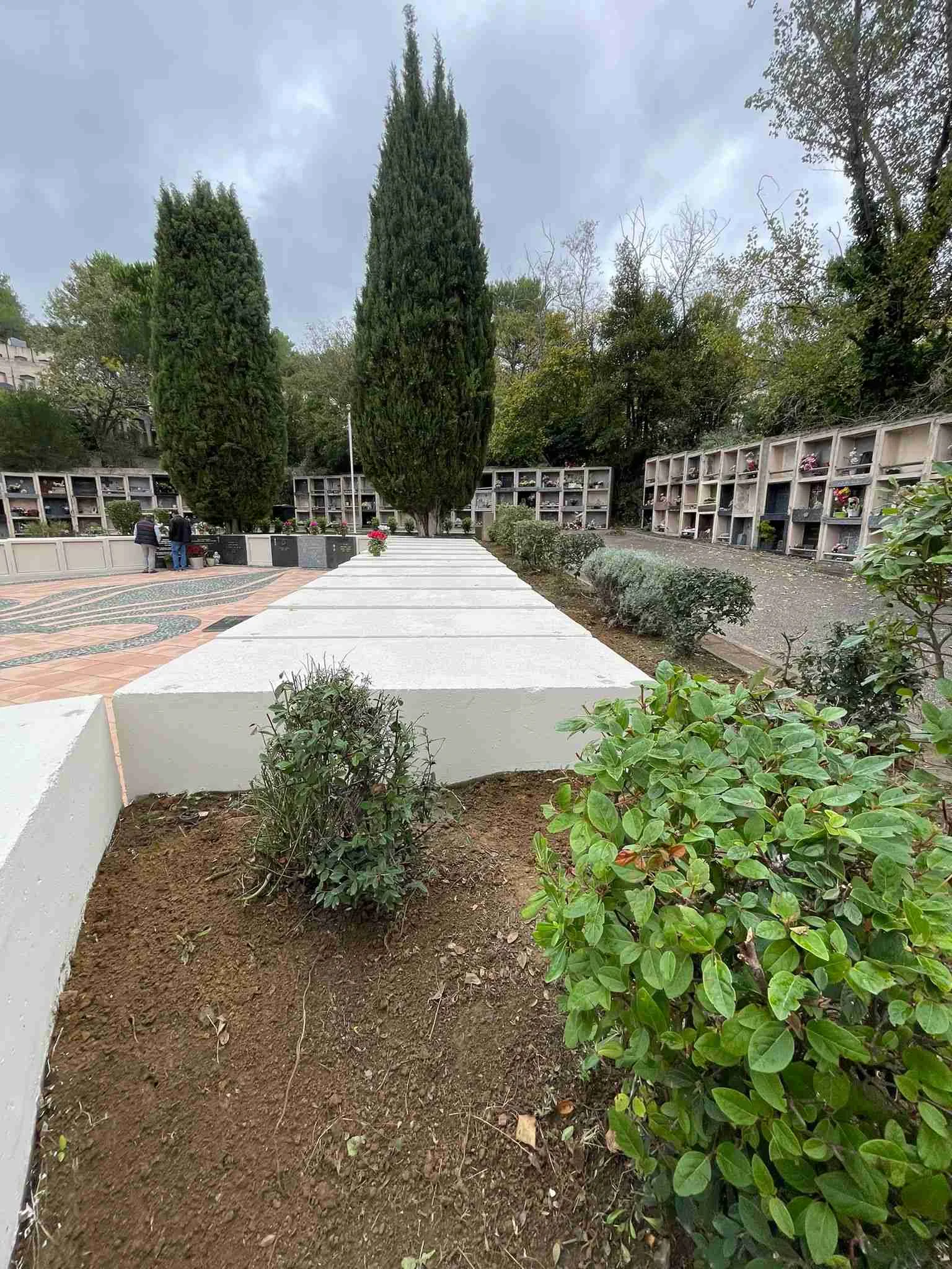 Rénovation cimetière - allées avec aménagement paysager frais, surfaces restaurées, cyprès et monuments commémoratifs