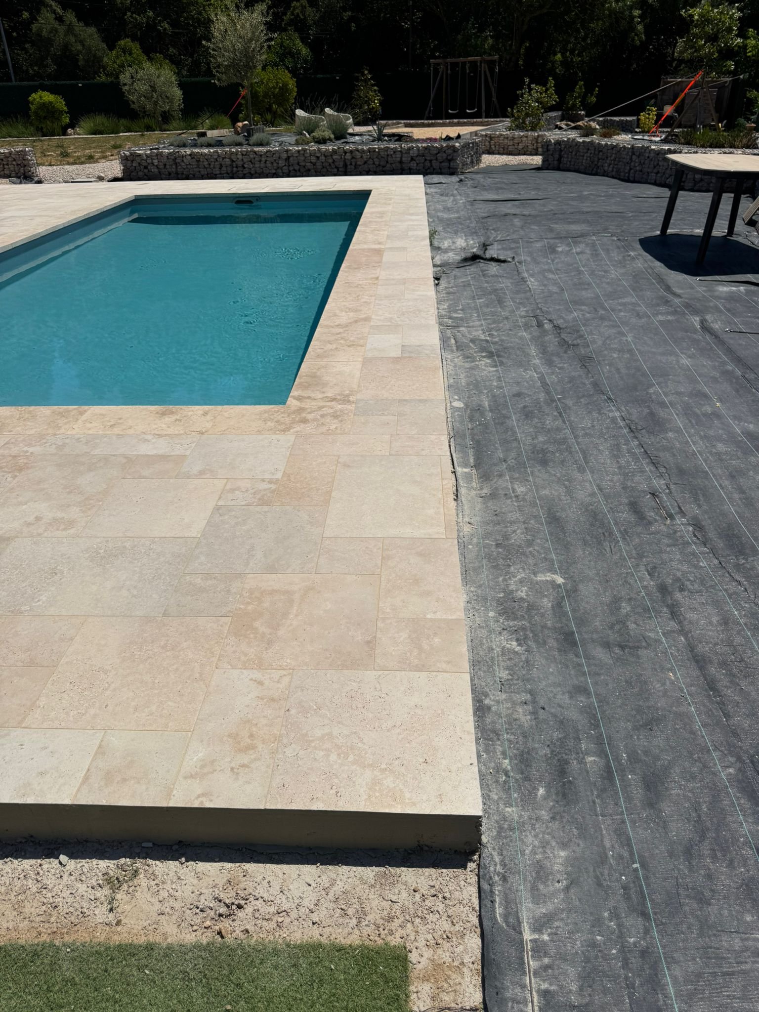Détail du dallage de la terrasse en pierre naturelle de grand format et margelle