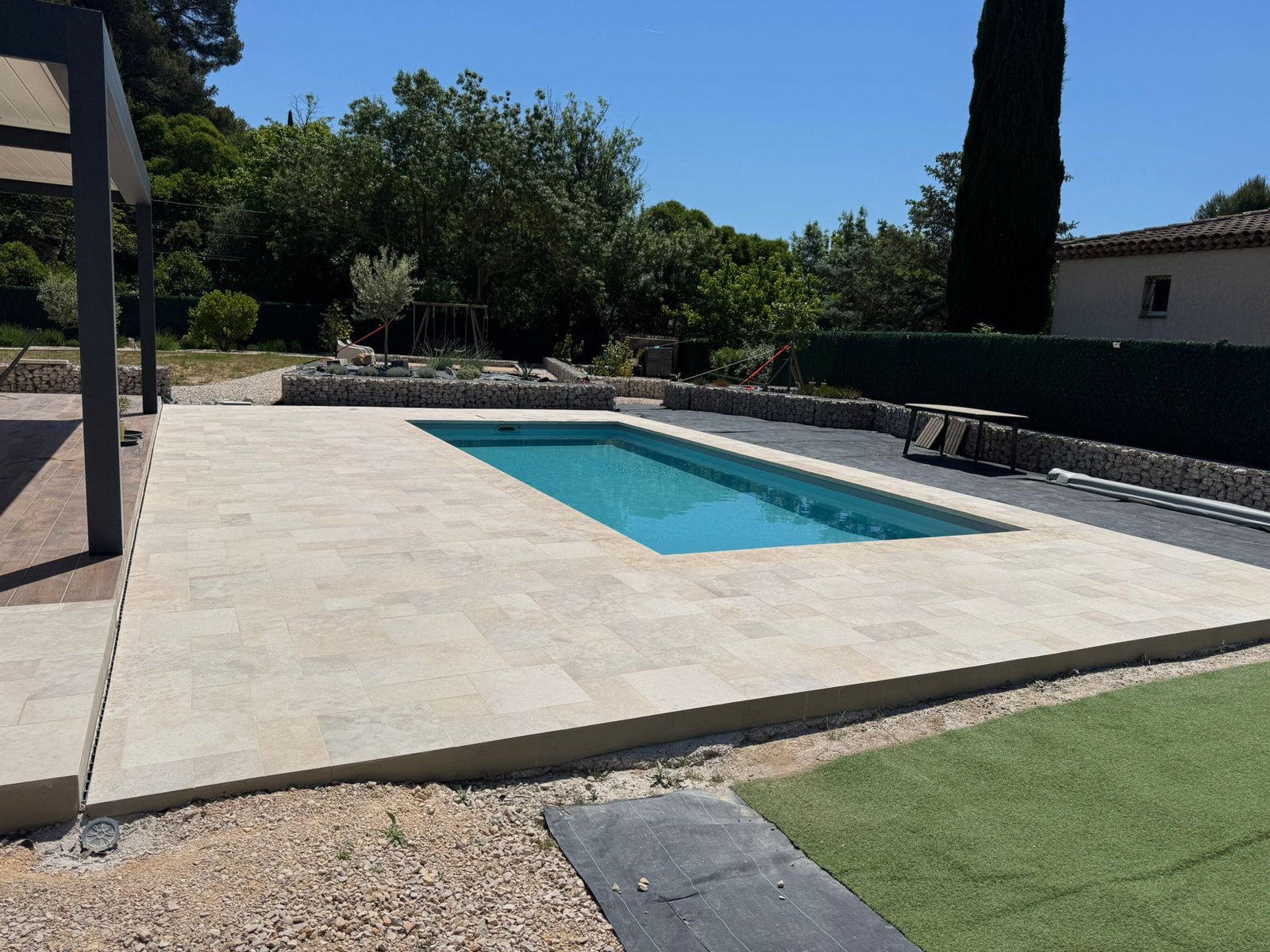 Espace de vie extérieur complet avec piscine à l'eau turquoise, terrasse et pergola