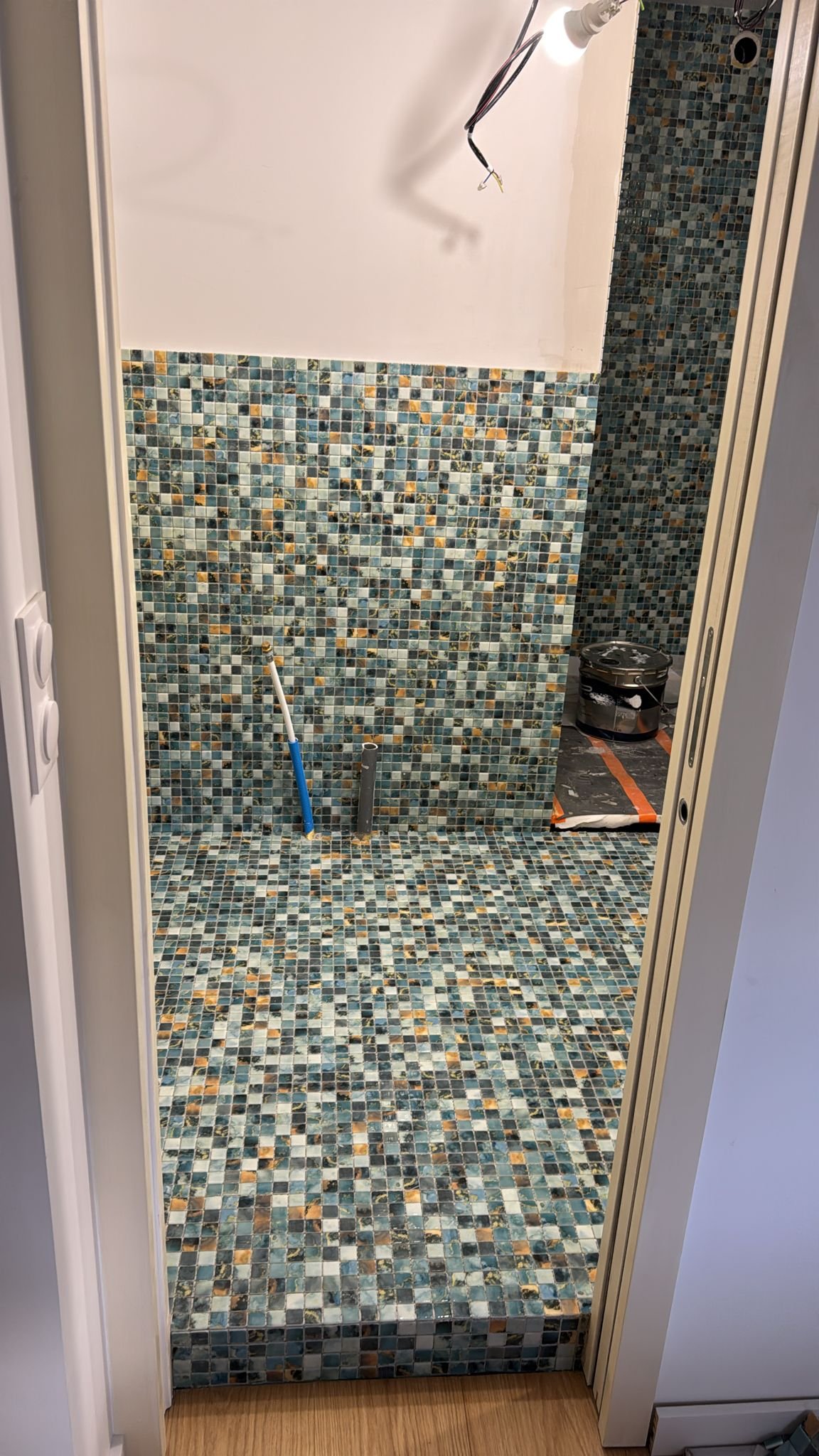 Détail du mur en mosaïque multicolore - carreaux turquoise, bleu, orange et crème