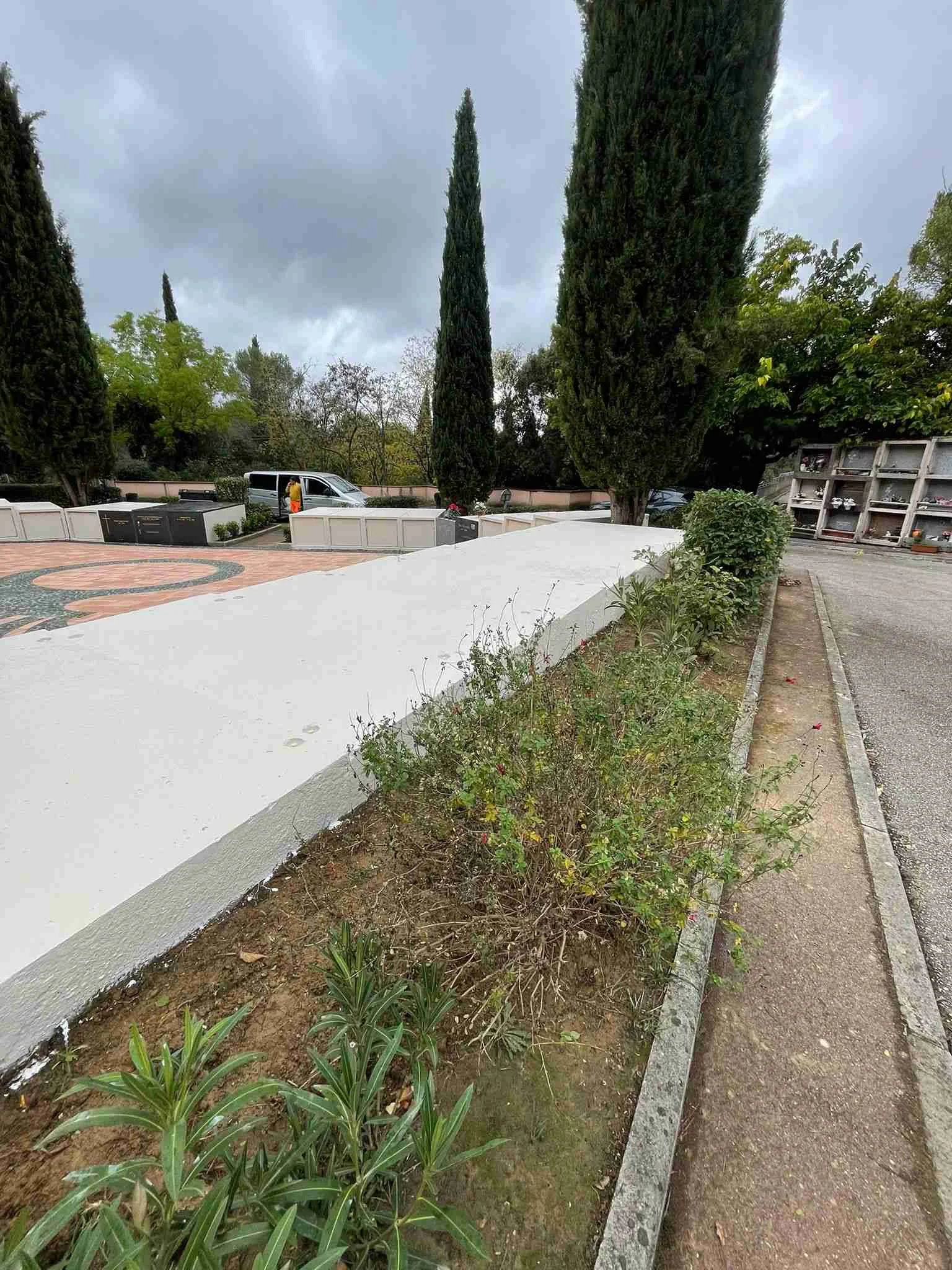 Rénovation cimetière - cour centrale avec pavage restauré, cyprès et monuments commémoratifs