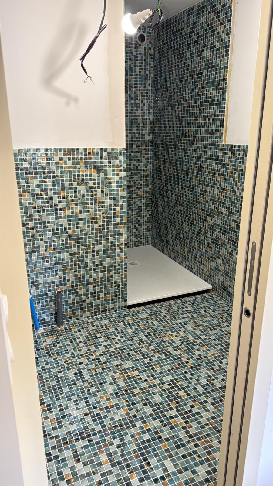 Espace douche avec carrelage mosaïque artistique et robinetterie chrome