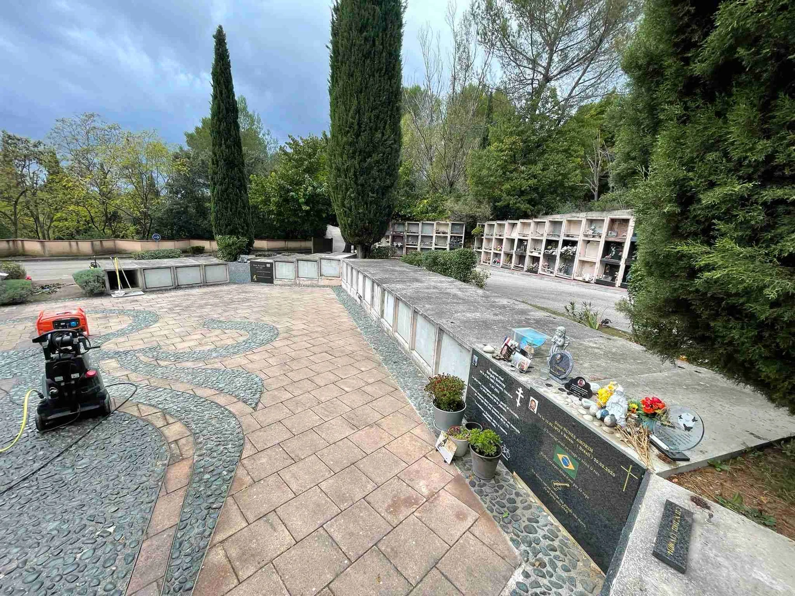 Rénovation cimetière - cour centrale avec pavage restauré, cyprès, zones commémoratives et aménagement paysager