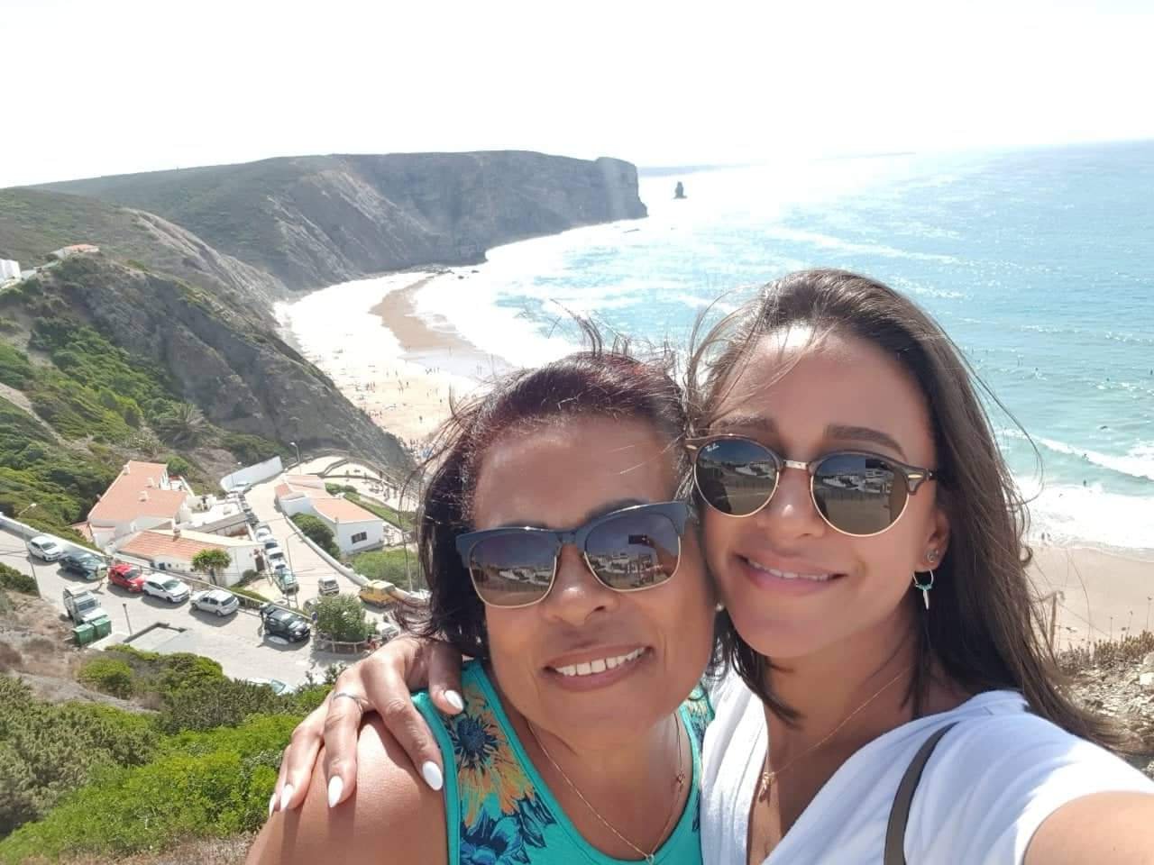 Katiane and her mum smiling together above a beach in Portugal